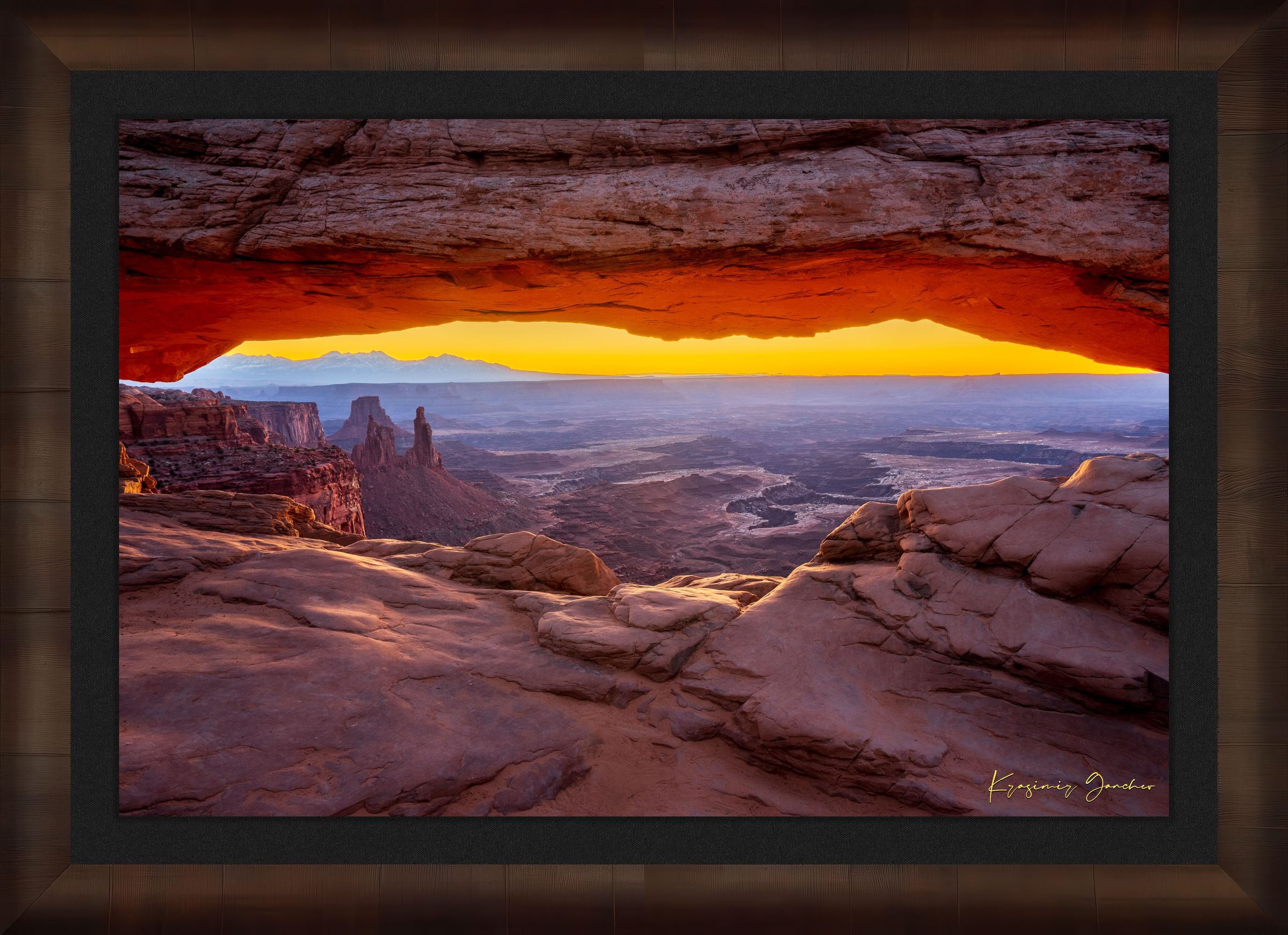 Mesa Arch in Canyonlands National Park framing a sunrise horizon under hazy skies, with golden rays illuminating rock formations. #Finish_Roma Cigar Leaf Frame & Dark Liner