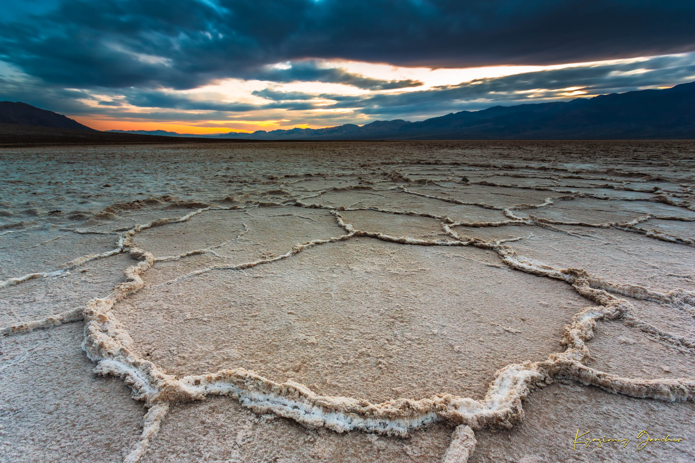 Expansive desert salt flat of Badwater Basin beneath a sky filled with storm clouds and setting sun in Death Valley. #Finish_Acrylic Recess