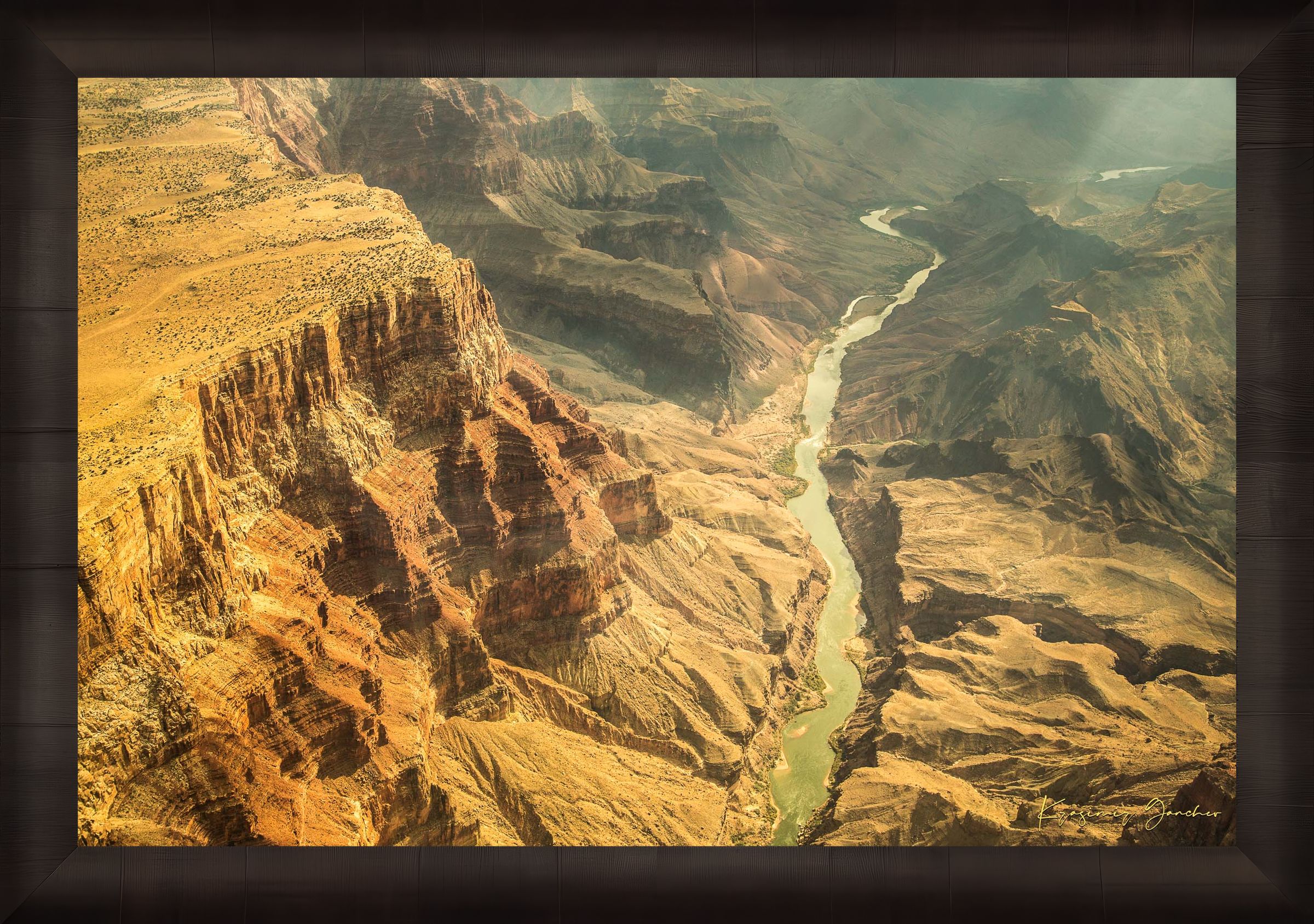 Colorado River traversing the Grand Canyon chasm in daylight, visible geological formations shrouded in haze. #Finish_Roma Dark Ash Frame