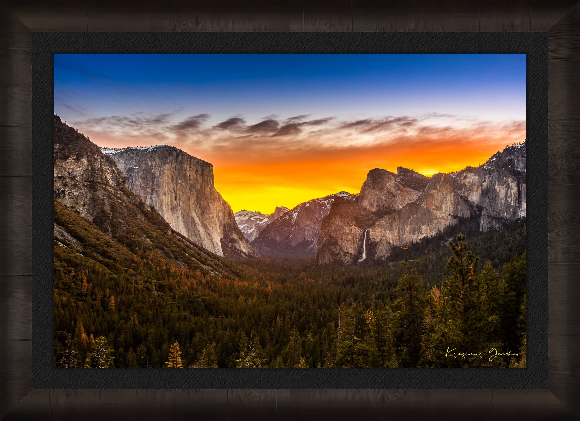 El Capitan rising above Yosemite Valley at sunrise, sunlit peaks framed by layered clouds. #Finish_Roma Dark Ash Frame & Dark Liner