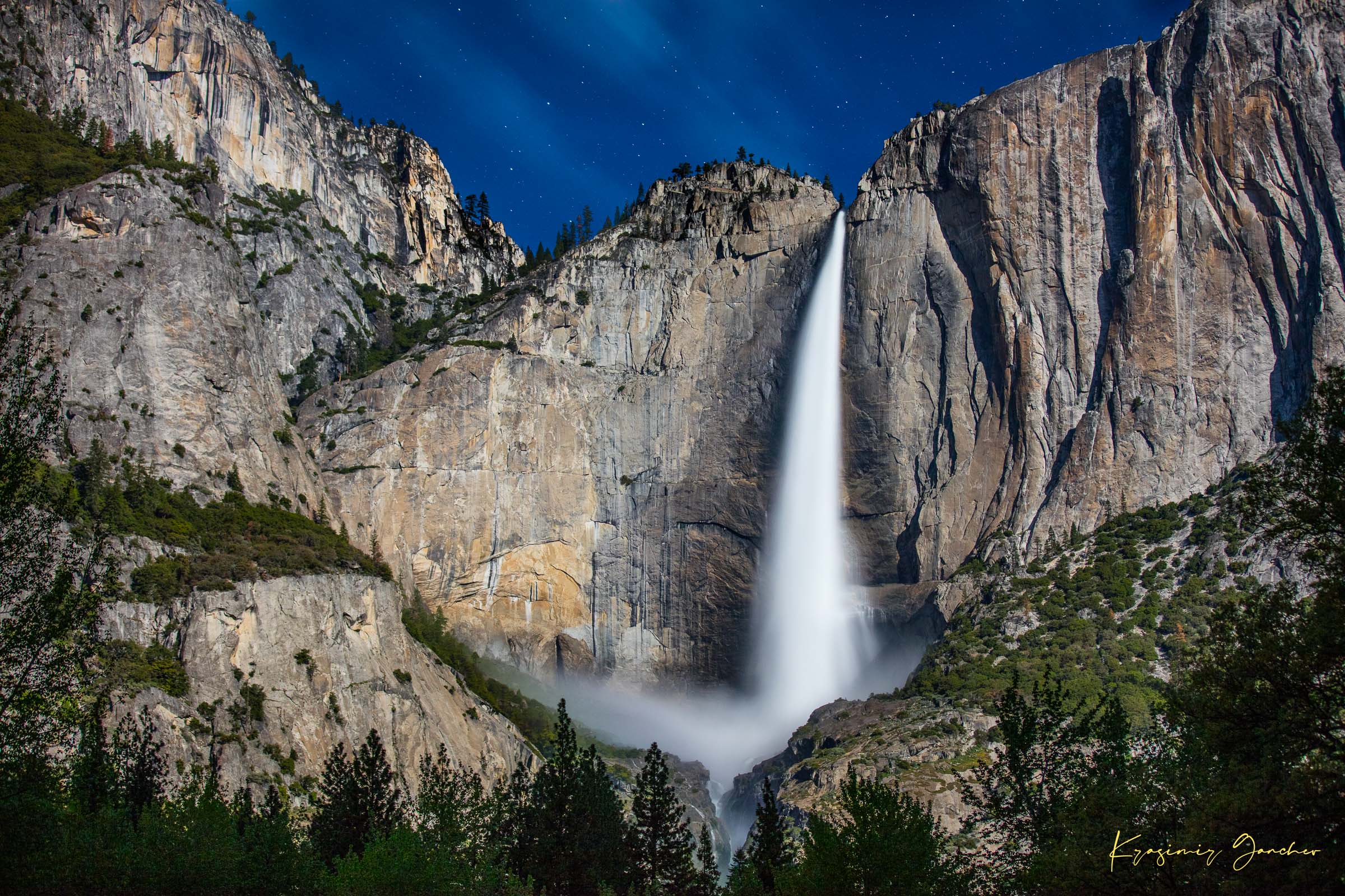 Upper Yosemite Falls illuminated by moonlight against a dark mountainous backdrop at night with cloud cover. #Finish_Acrylic Recess