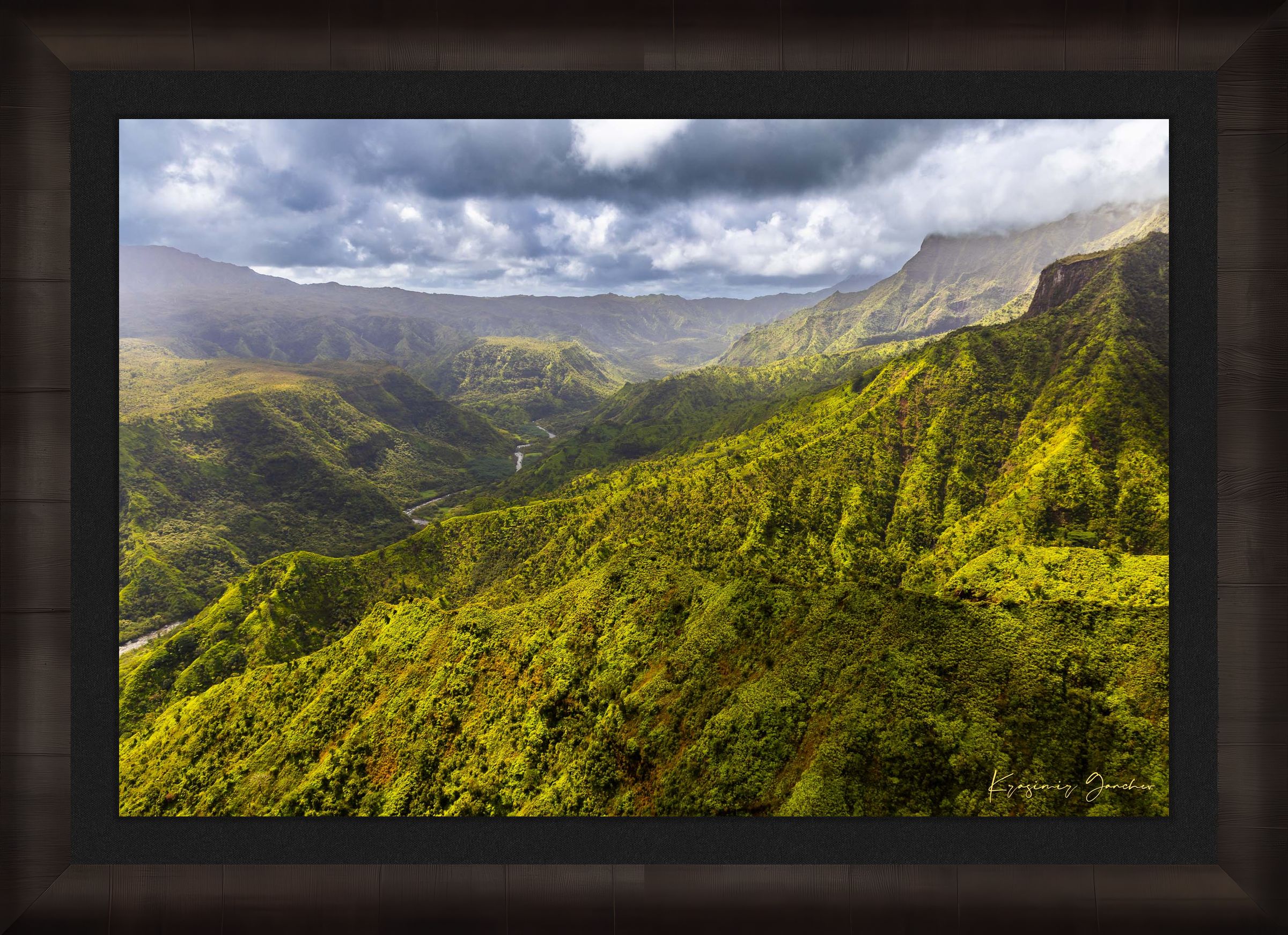Expansive aerial view of a mountainous valley in Kauai illuminated by daylight, covered in low-lying cloud. #Finish_Roma Dark Ash Frame & Dark Liner