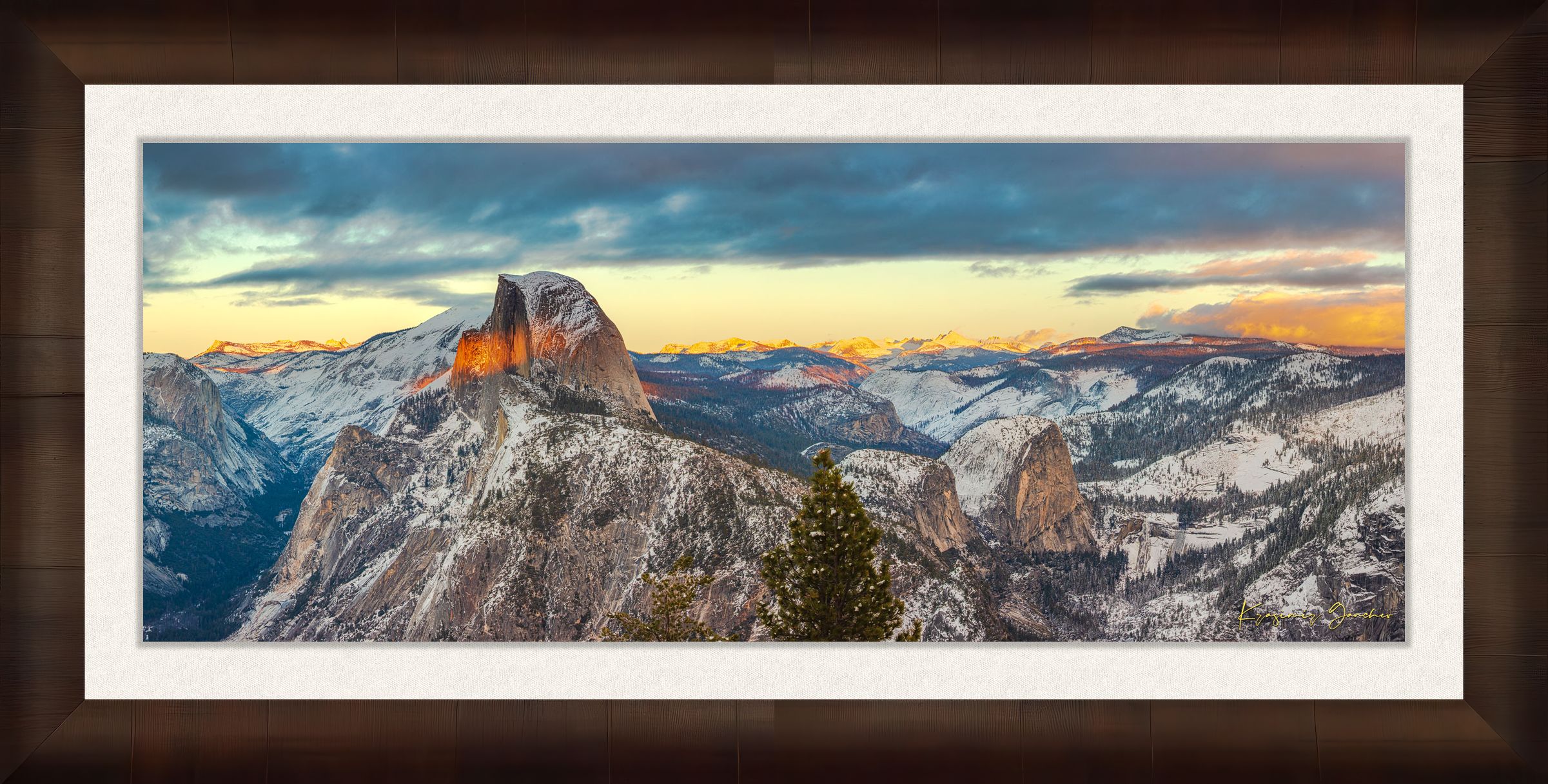 Sunset view of Half Dome monolith with dynamic shadows and sunlight over snow-dusted peaks and clouds in Yosemite National Park. #Finish_Roma Cigar Leaf Frame & Bright Liner