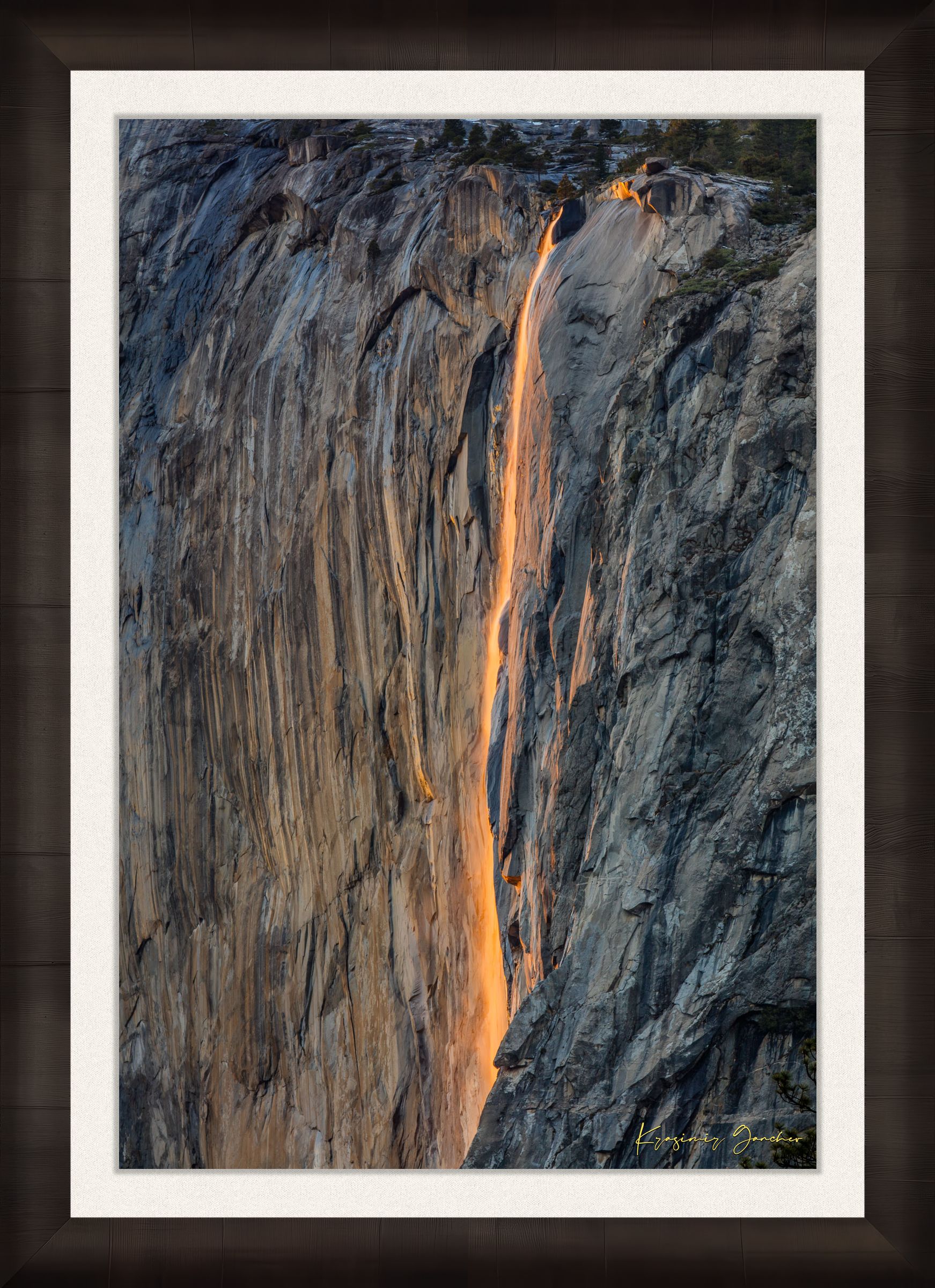 Detailed view of the firefall effect on El Capitan monolith with glowing sunlight refracting through mist from Horsetail Fall in Yosemite. #Finish_Roma Dark Ash Frame & Bright Liner