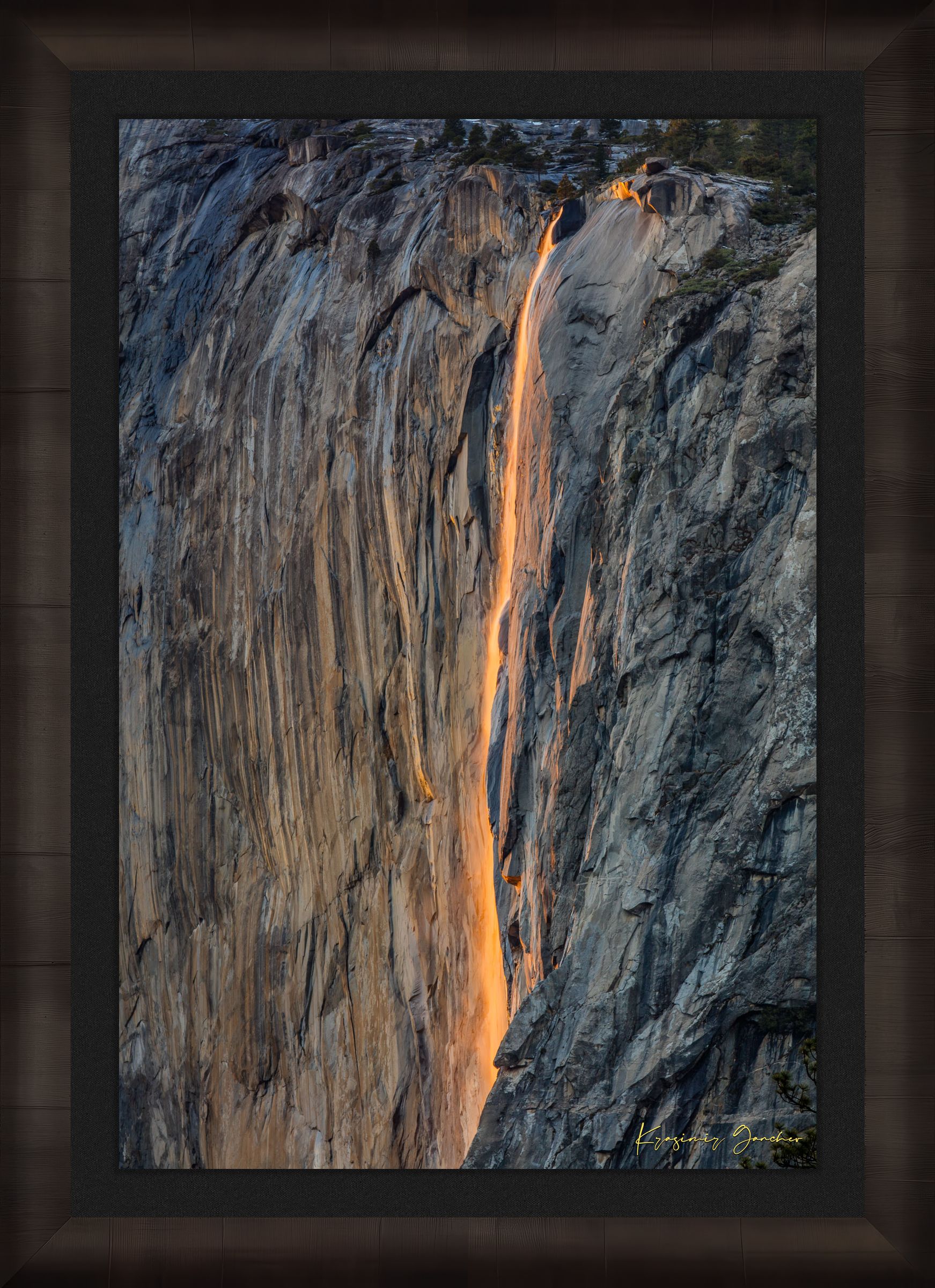 Detailed view of the firefall effect on El Capitan monolith with glowing sunlight refracting through mist from Horsetail Fall in Yosemite. #Finish_Roma Dark Ash Frame & Dark Liner