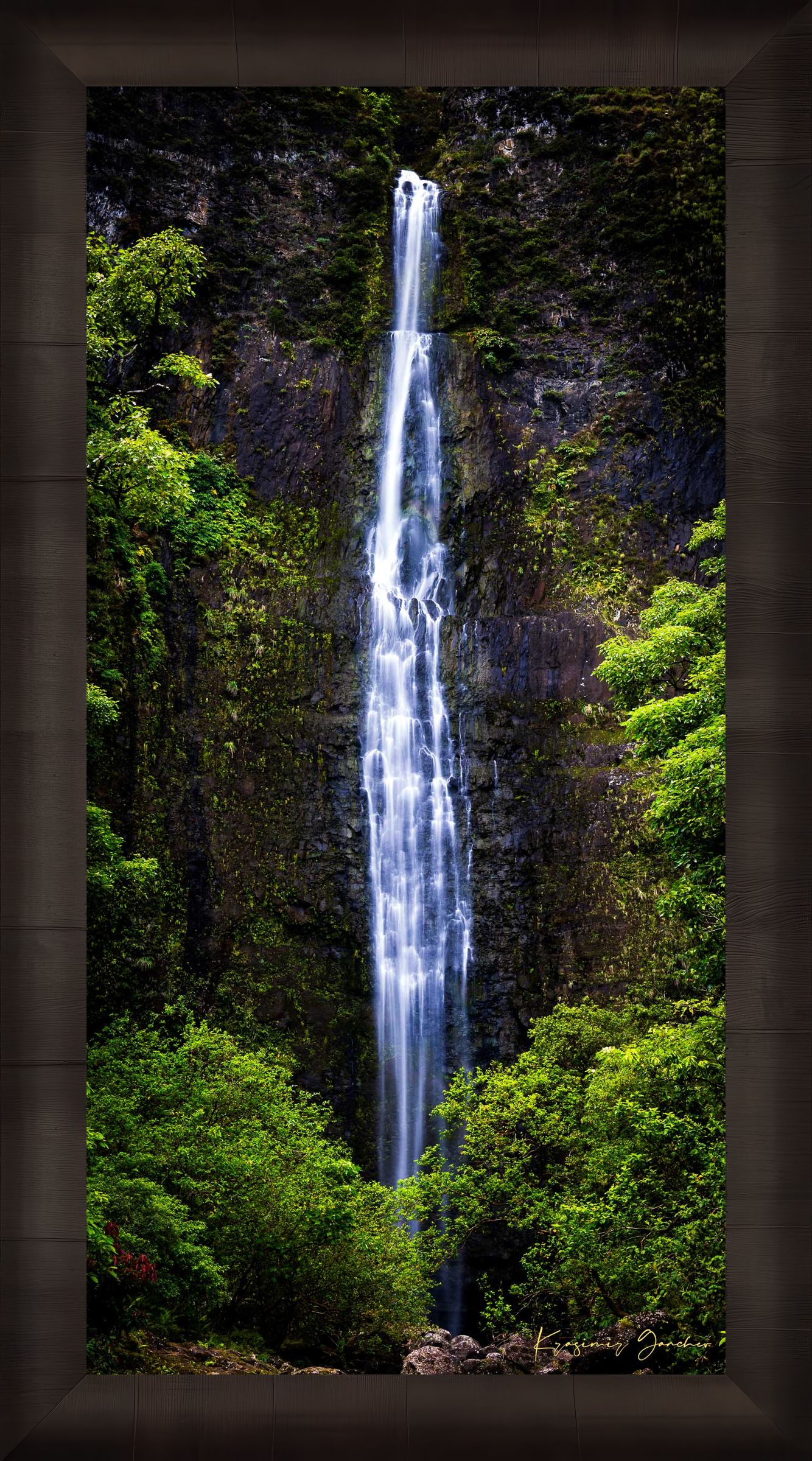 Waterfall cascading down cliff face within Na Pali Coast region of Kauai under daylight conditions. #Finish_Roma Dark Ash Frame