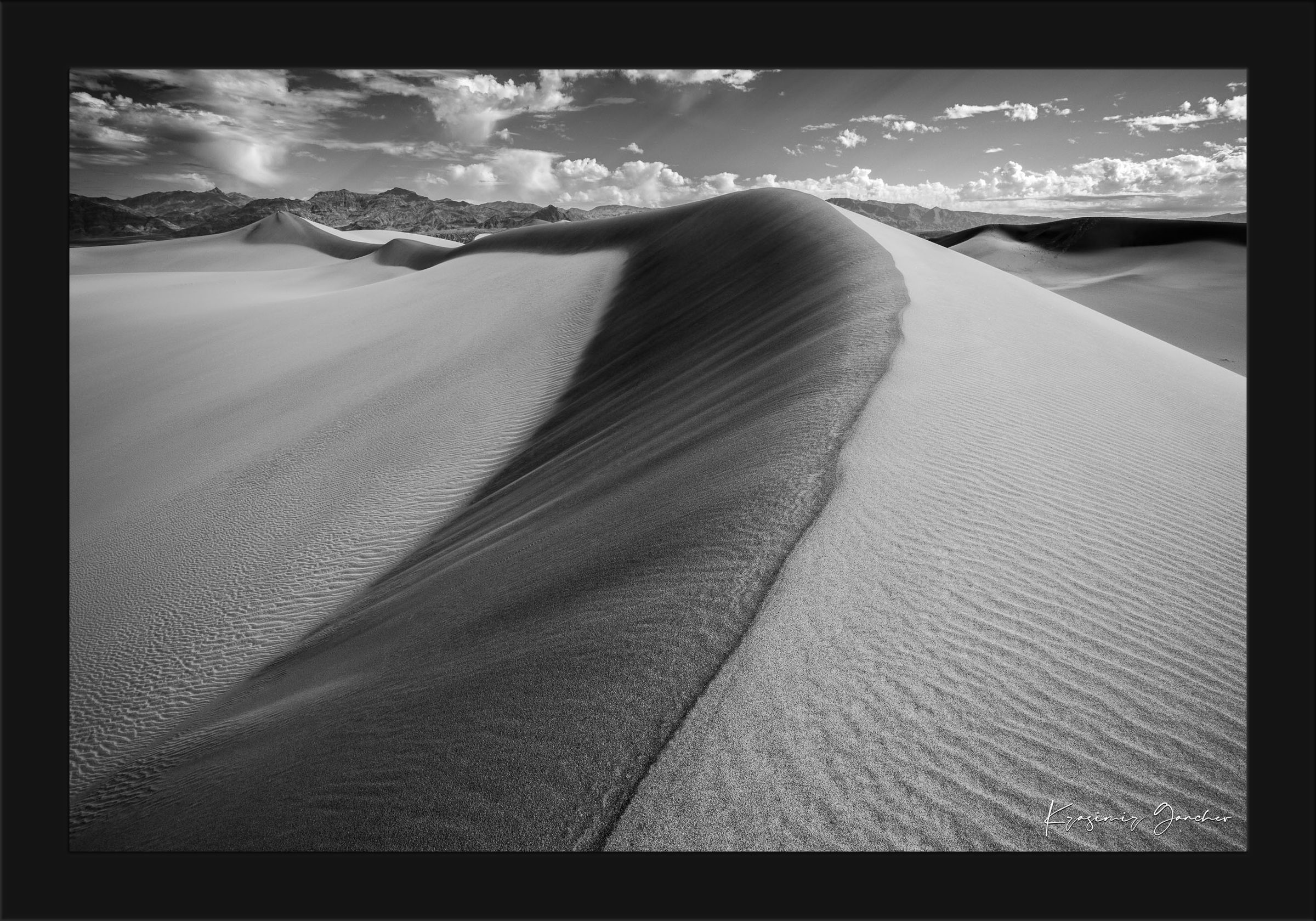 Monochrome sand dune landscape in Death Valley National Park, showing smooth contours and natural textures under daytime lighting. #Finish_Roma Satin Black Frame