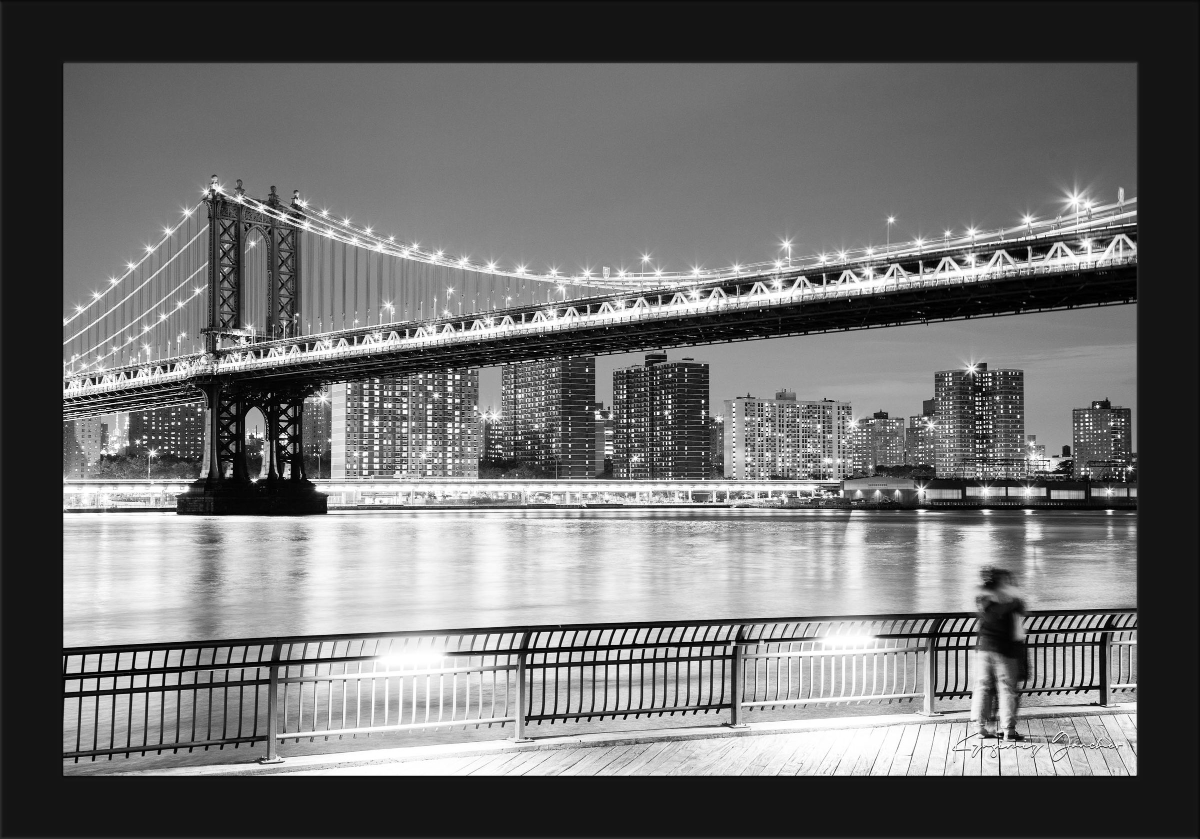 Monochrome Brooklyn Bridge at night across the Manhattan estuary, illuminated by city lights. #Finish_Roma Satin Black Frame