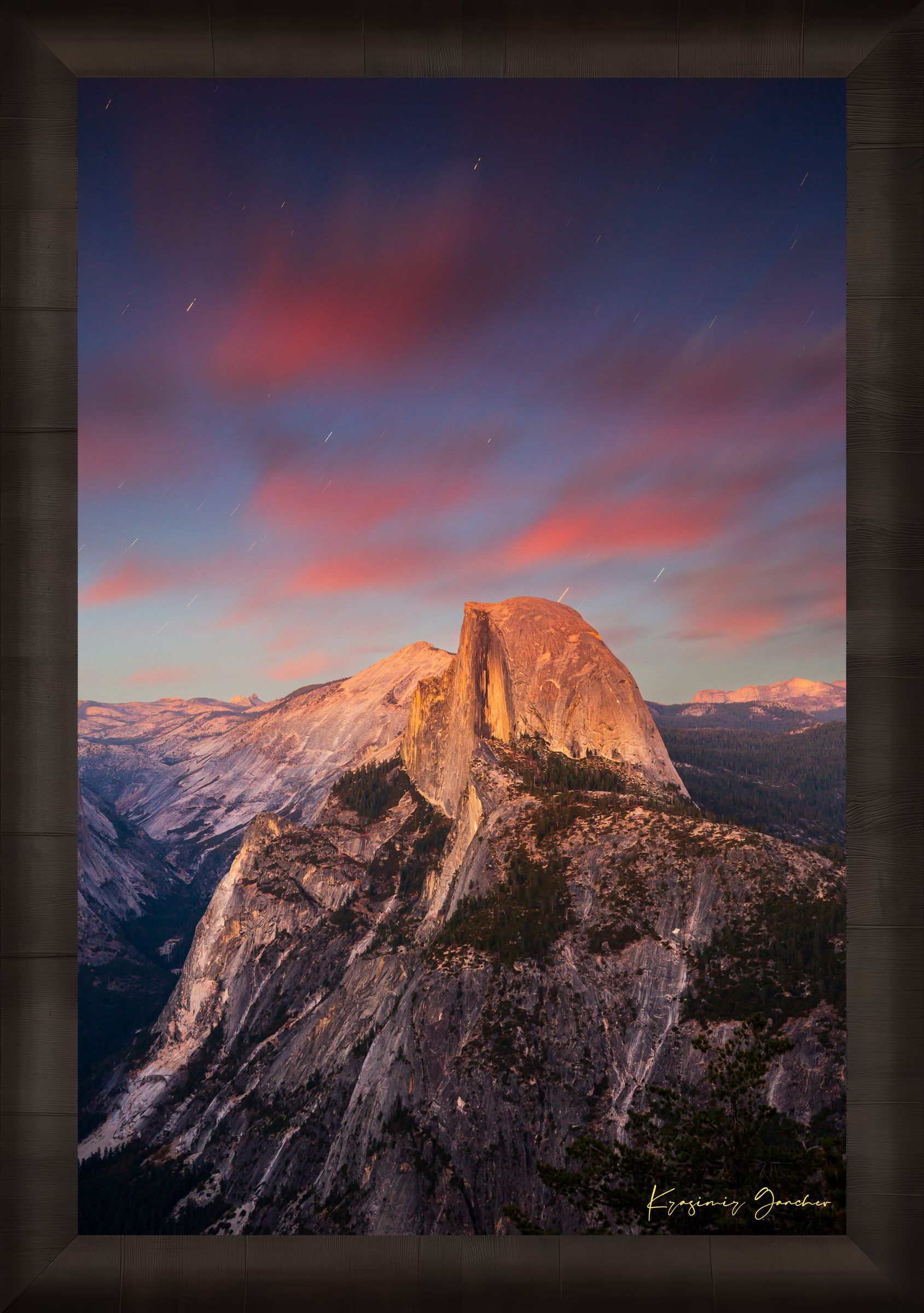 Granite monolith of Half Dome illuminated by dusk and stars, set against a sky filled with star trails above Yosemite National Park. #Finish_Roma Dark Ash Frame
