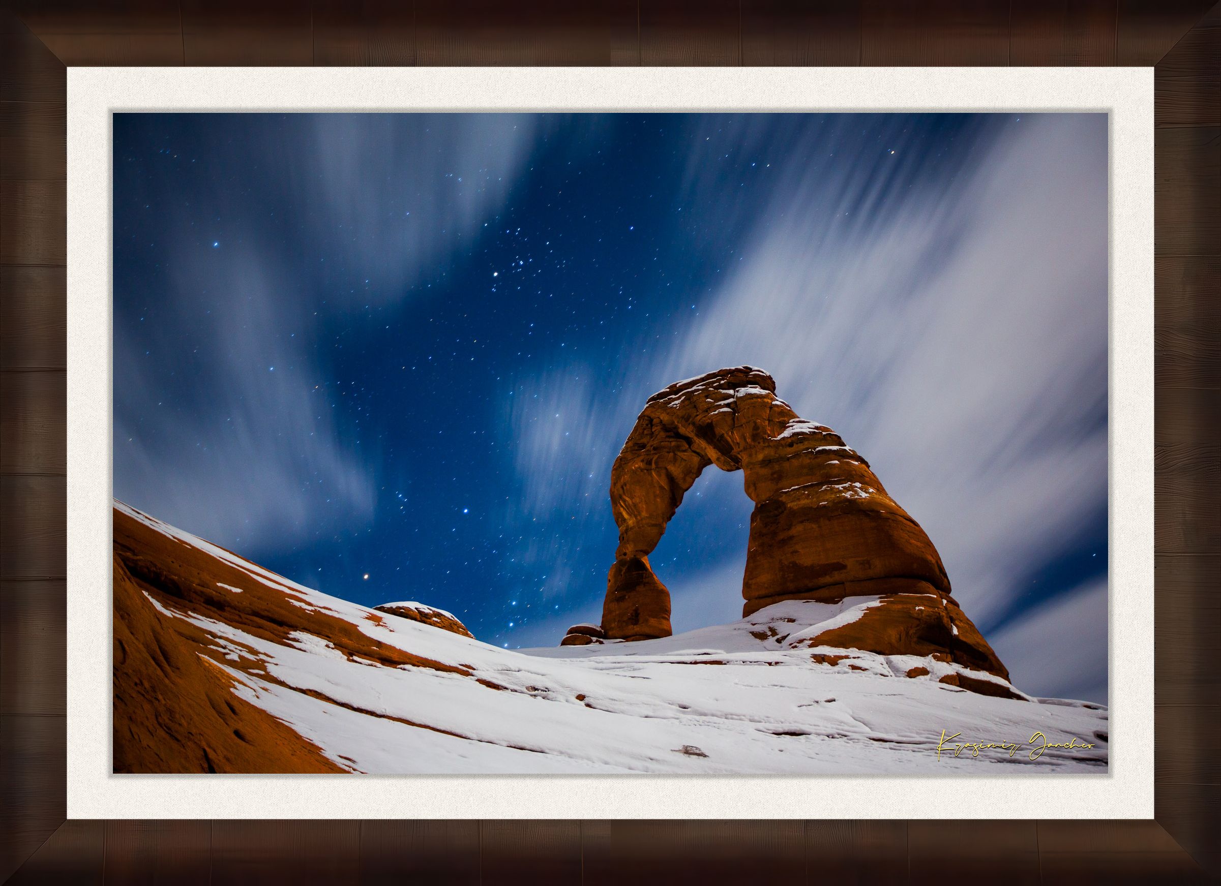 Iconic arch formation in Arches National Park captured during nighttime with starlight and light snow enhancing the serene desert scene. #Finish_Roma Cigar Leaf Frame & Bright Liner