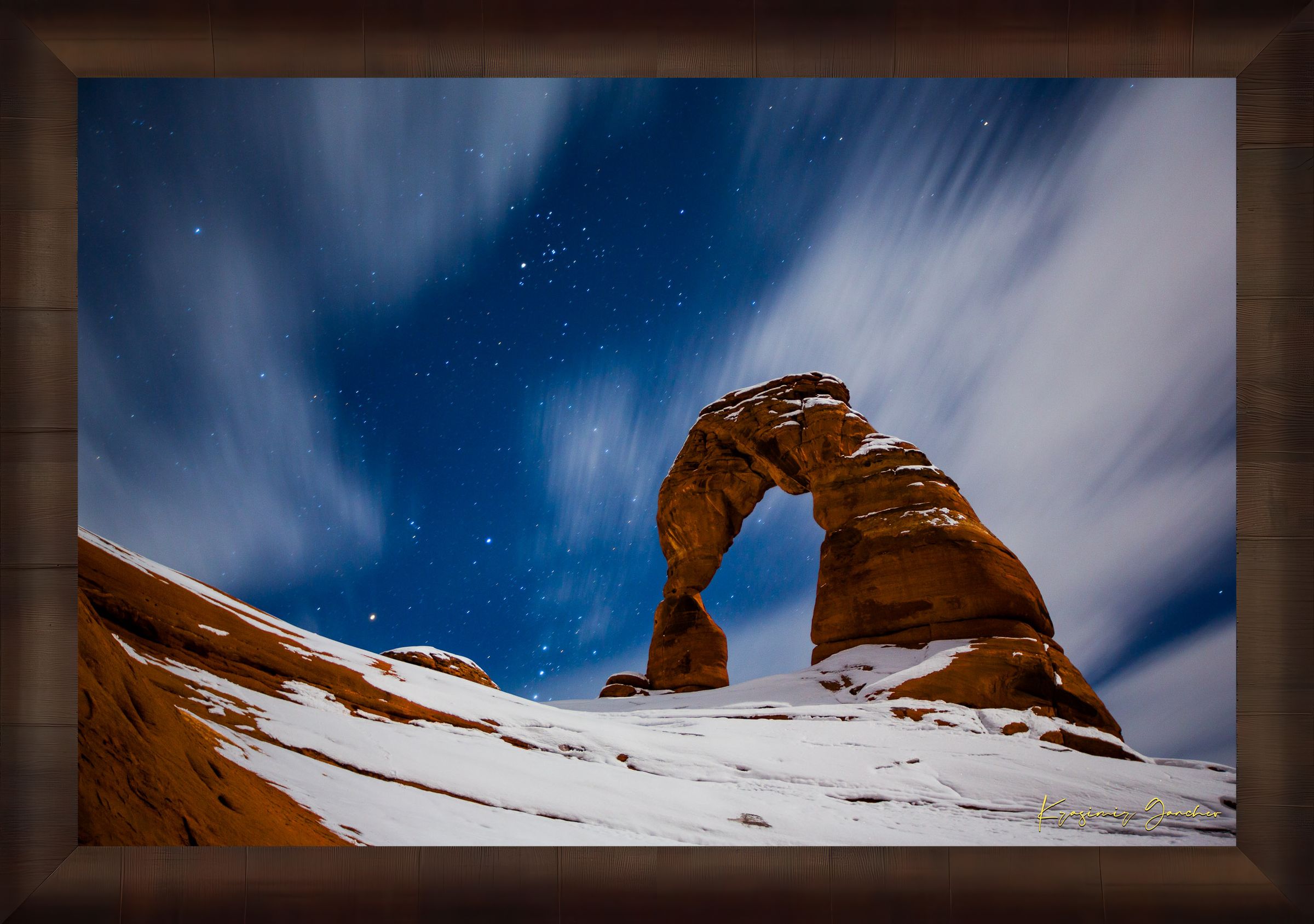 Iconic arch formation in Arches National Park captured during nighttime with starlight and light snow enhancing the serene desert scene. #Finish_Roma Cigar Leaf Frame