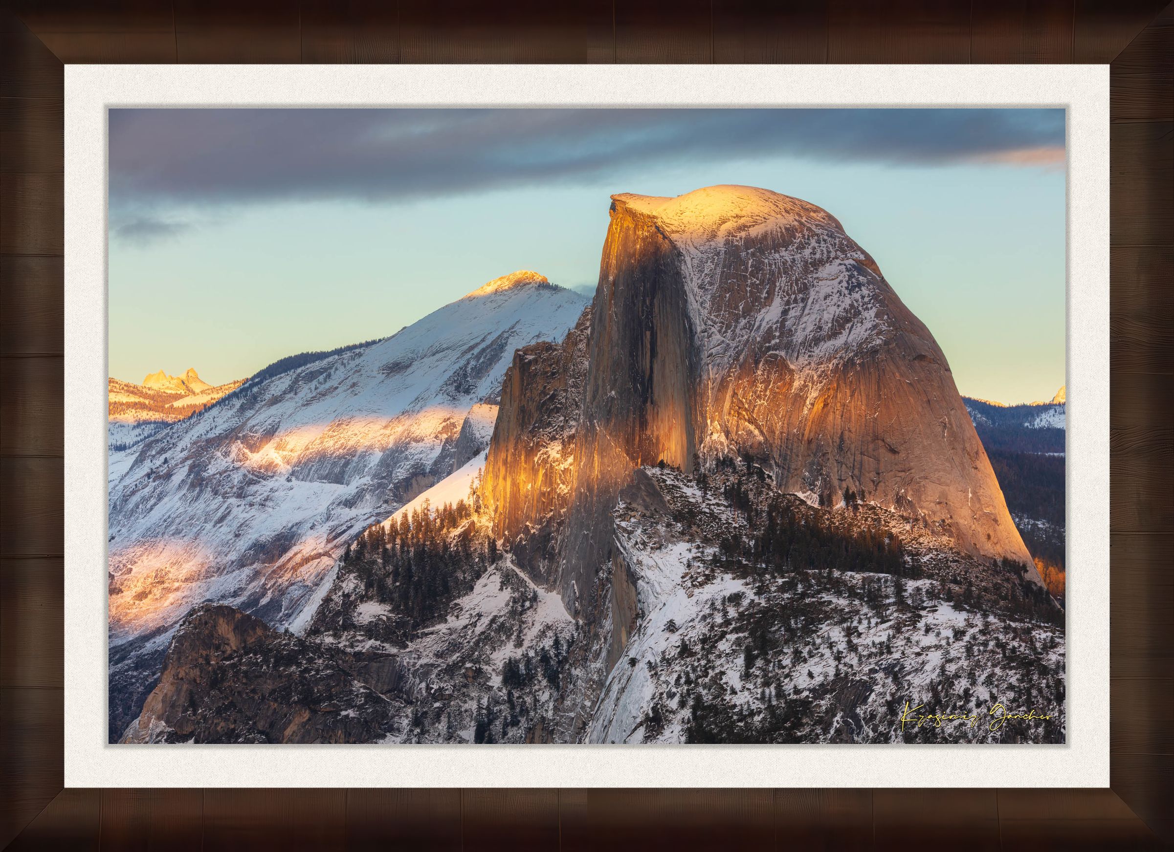 Half Dome monolith illuminated by golden sunset light amidst snow-covered peaks and clouds in Yosemite National Park. #Finish_Roma Cigar Leaf Frame & Bright Liner