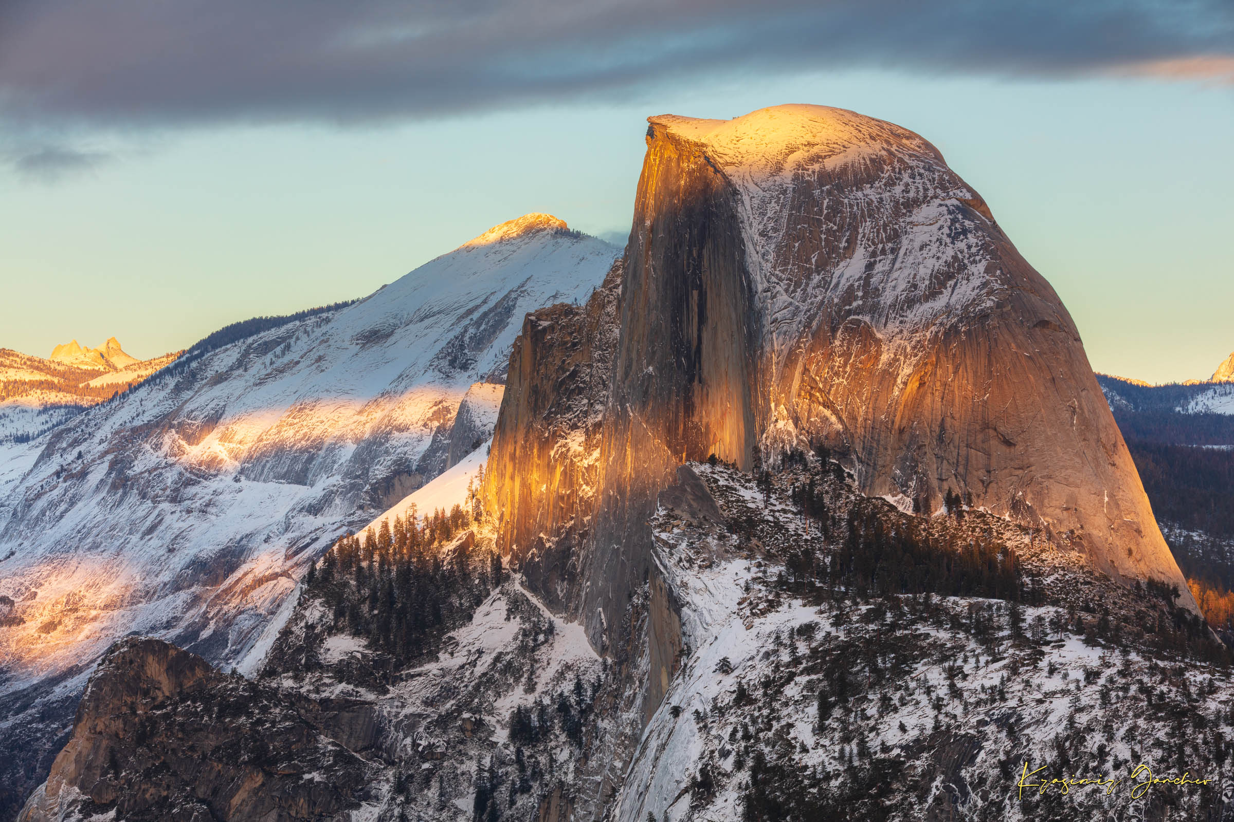 Half Dome monolith illuminated by golden sunset light amidst snow-covered peaks and clouds in Yosemite National Park. #Finish_Acrylic Recess