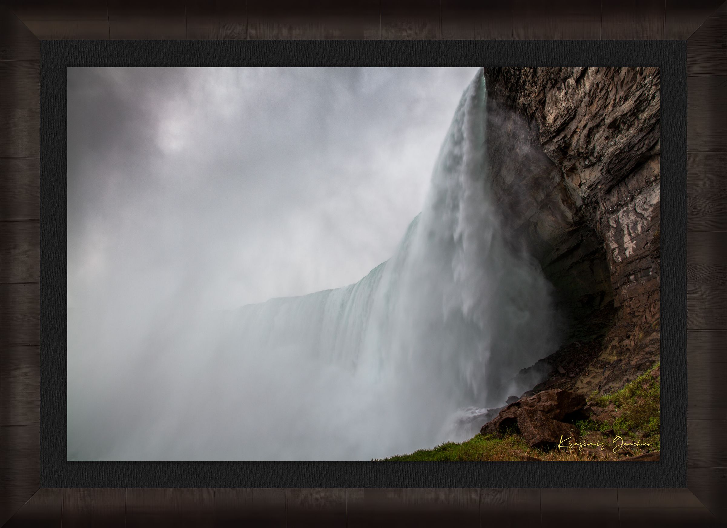 Waterfall descending from cliff edge at Niagara Falls, surrounded by mist and storm clouds. #Finish_Roma Dark Ash Frame & Dark Liner