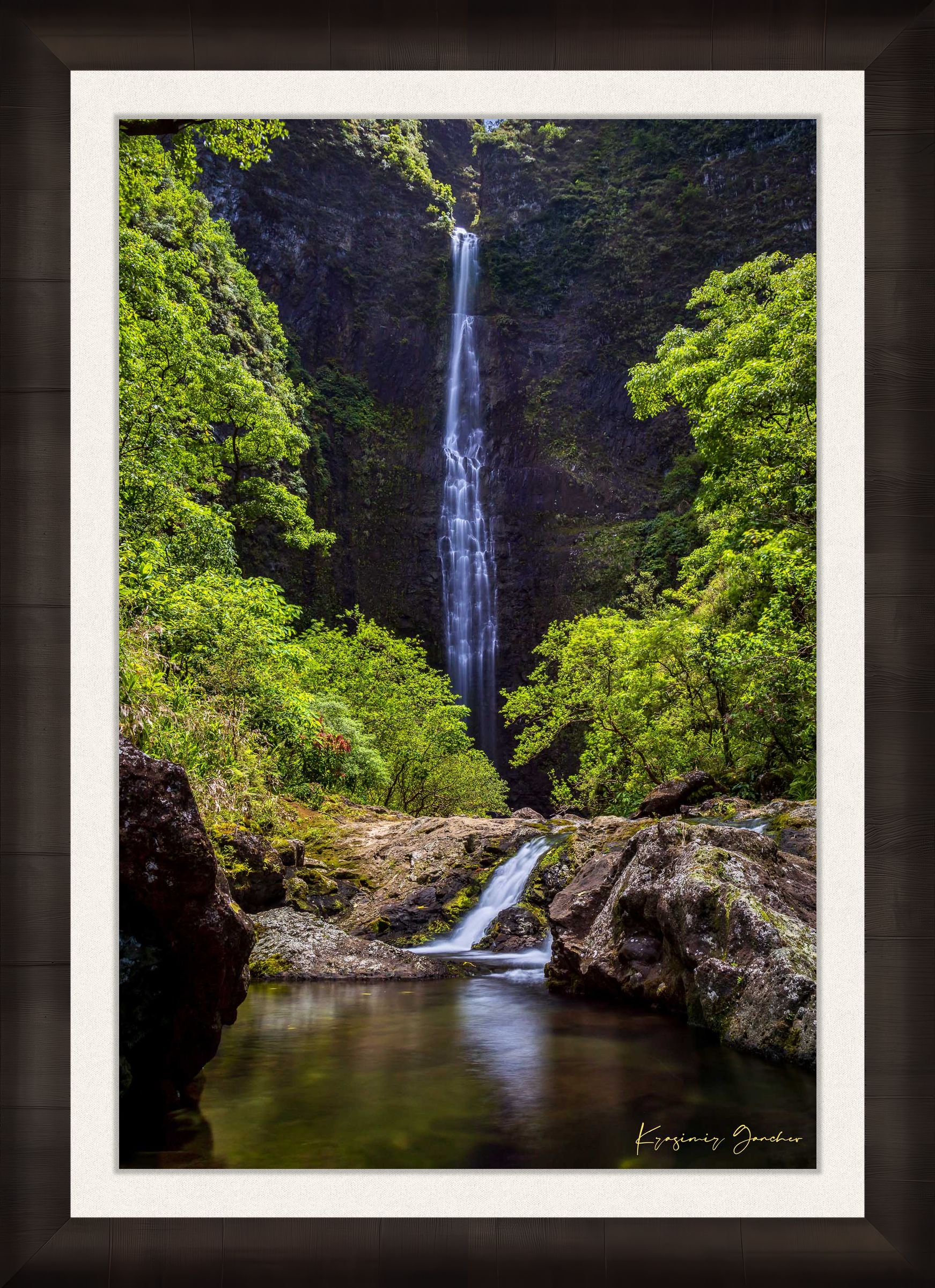 Small waterfall veiled in mist beneath dense foliage at Hanakapiai Falls, Kauai, lit by daylight. #Finish_Roma Dark Ash Frame & Bright Liner