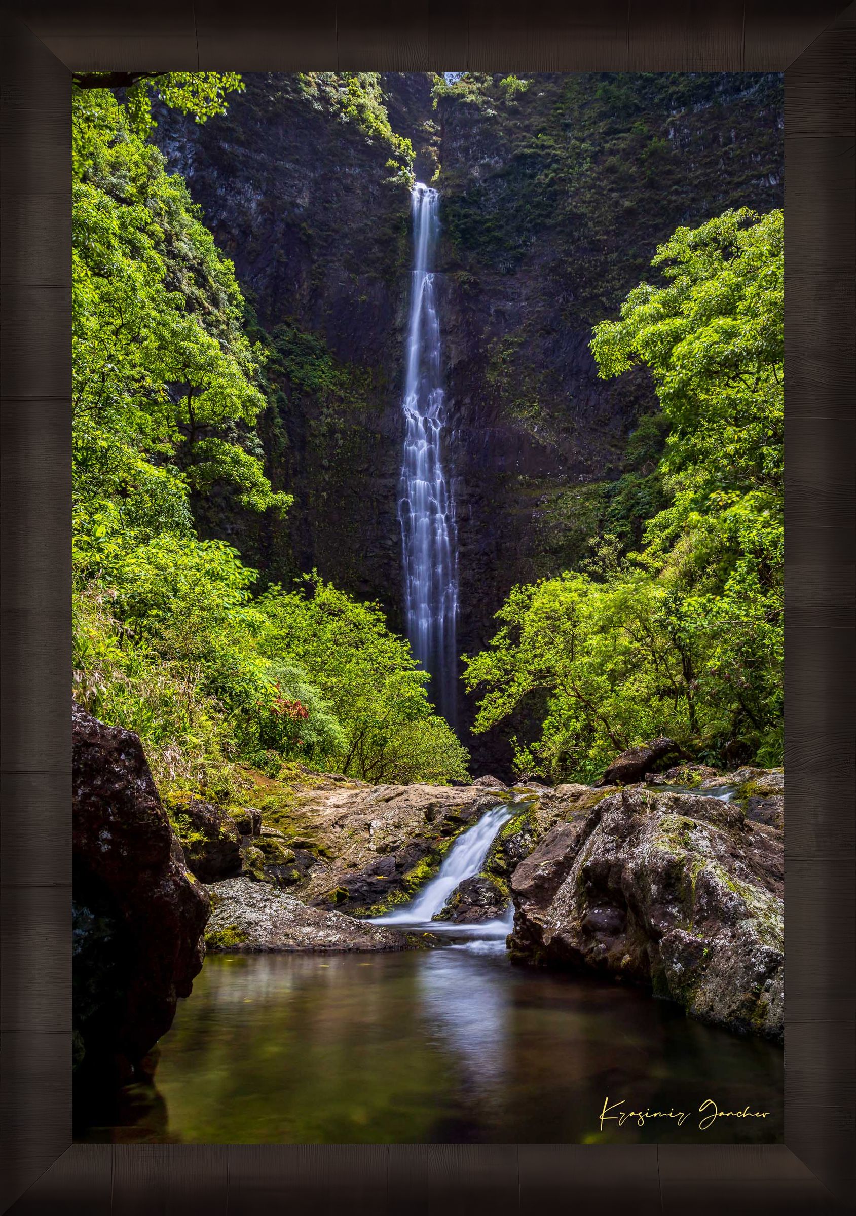 Small waterfall veiled in mist beneath dense foliage at Hanakapiai Falls, Kauai, lit by daylight. #Finish_Roma Dark Ash Frame