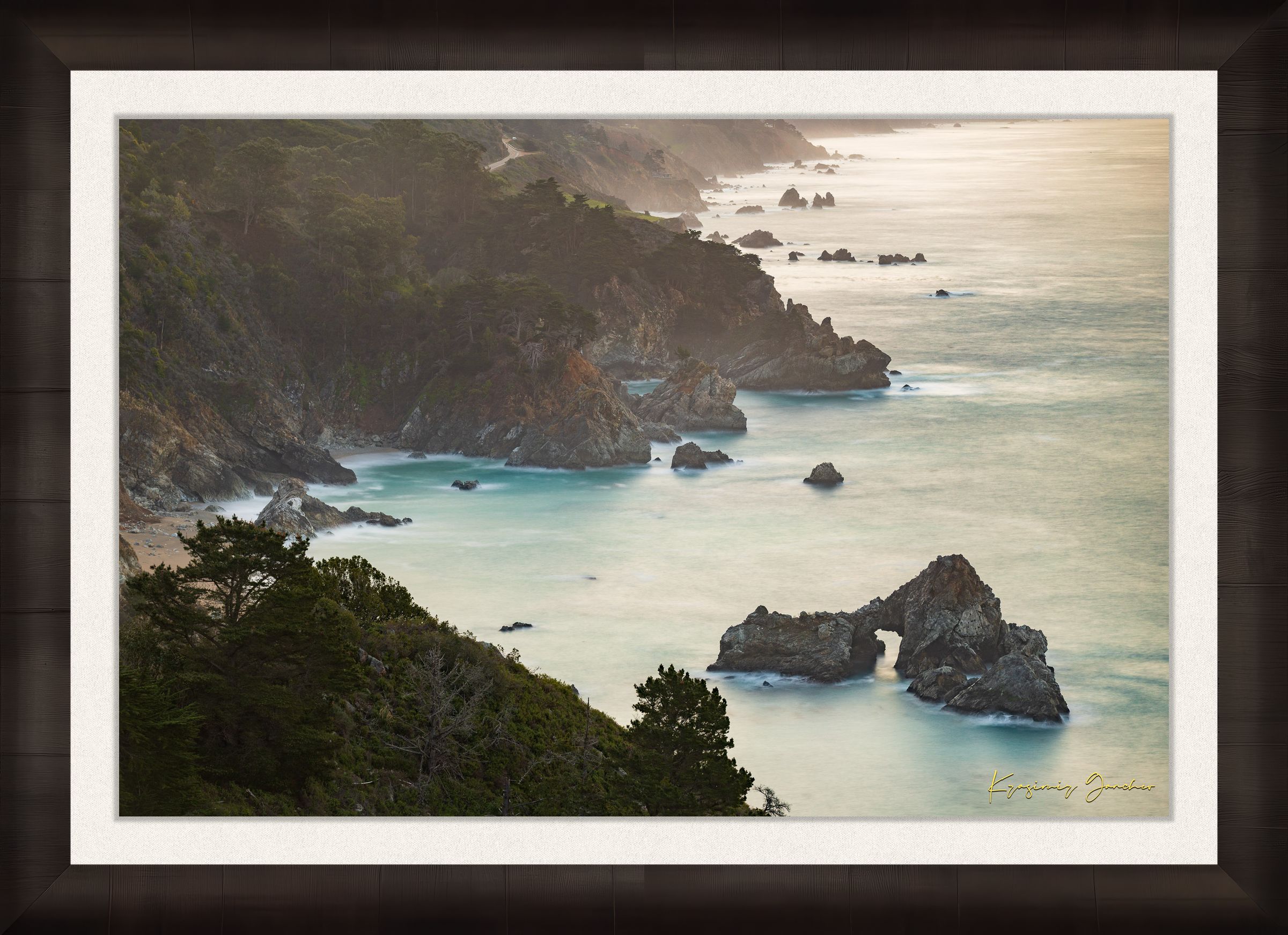 Coastal rock formation known as McWay Rocks at dawn on the Big Sur coastline with lush vegetation and ocean view. #Finish_Roma Dark Ash Frame & Bright Liner
