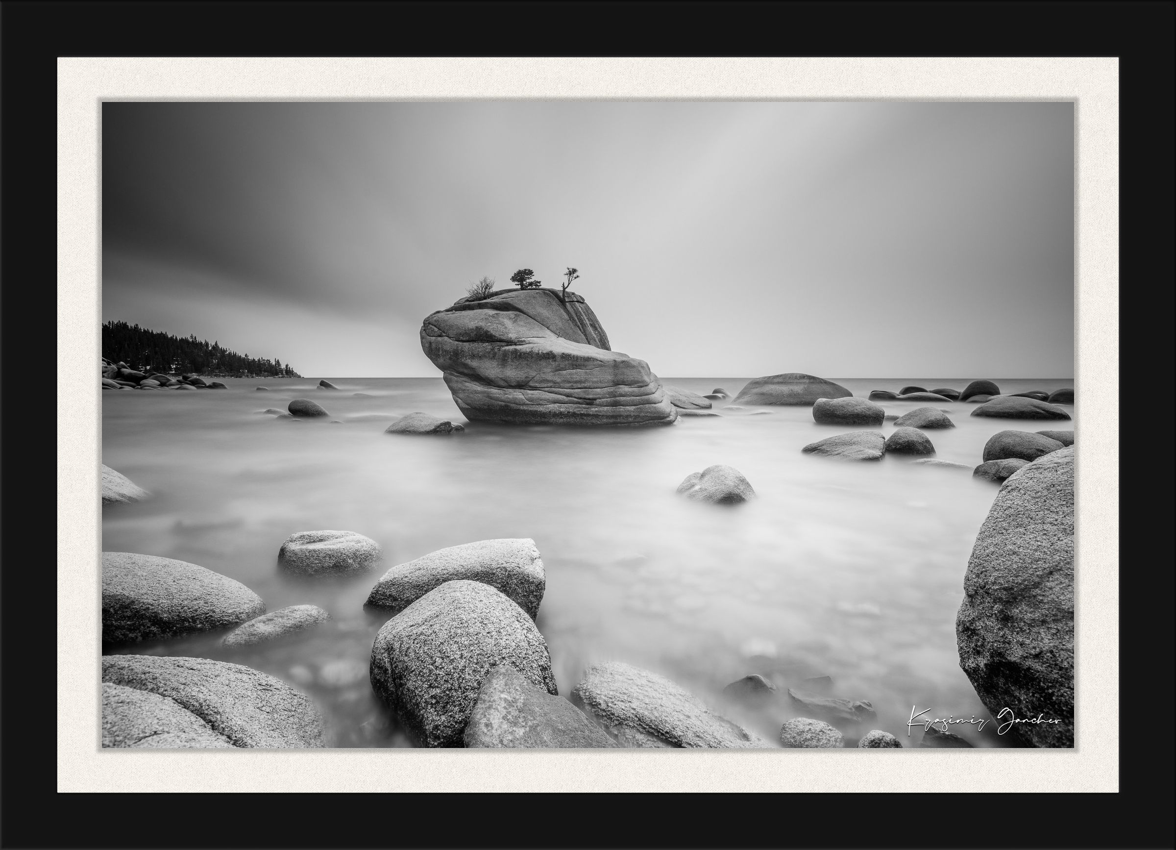 Large boulder named Bonsai Rock in Lake Tahoe surrounded by still, reflective waters under daytime light. #Finish_Roma Satin Black Frame & Bright Liner