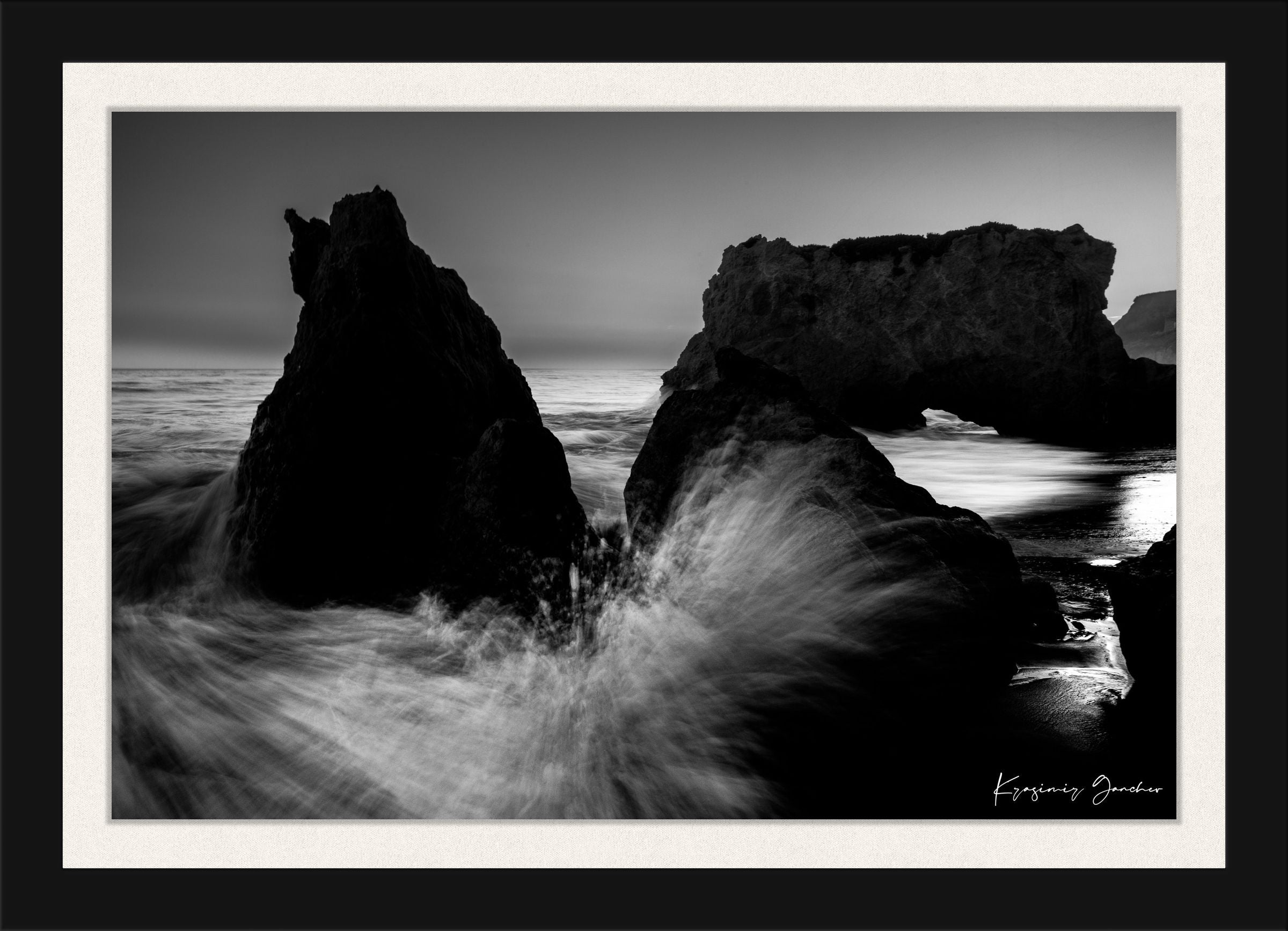 Rock arch formation along the coastal ocean at El Matador Beach, Malibu, California, with crashing waves and dusky atmosphere. #Finish_Roma Satin Black Frame & Bright Liner