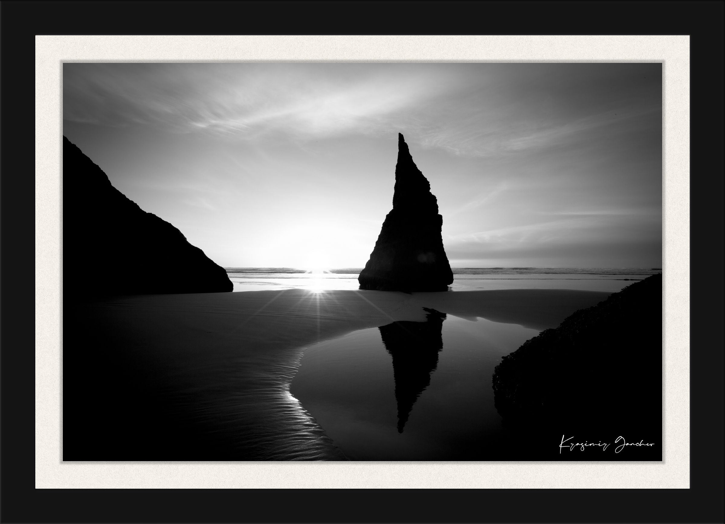 Black and white photograph of the Wizards Hat sea stack at Bandon Beach under hazy sunlight with clouds and ocean reflections. #Finish_Roma Satin Black Frame & Bright Liner