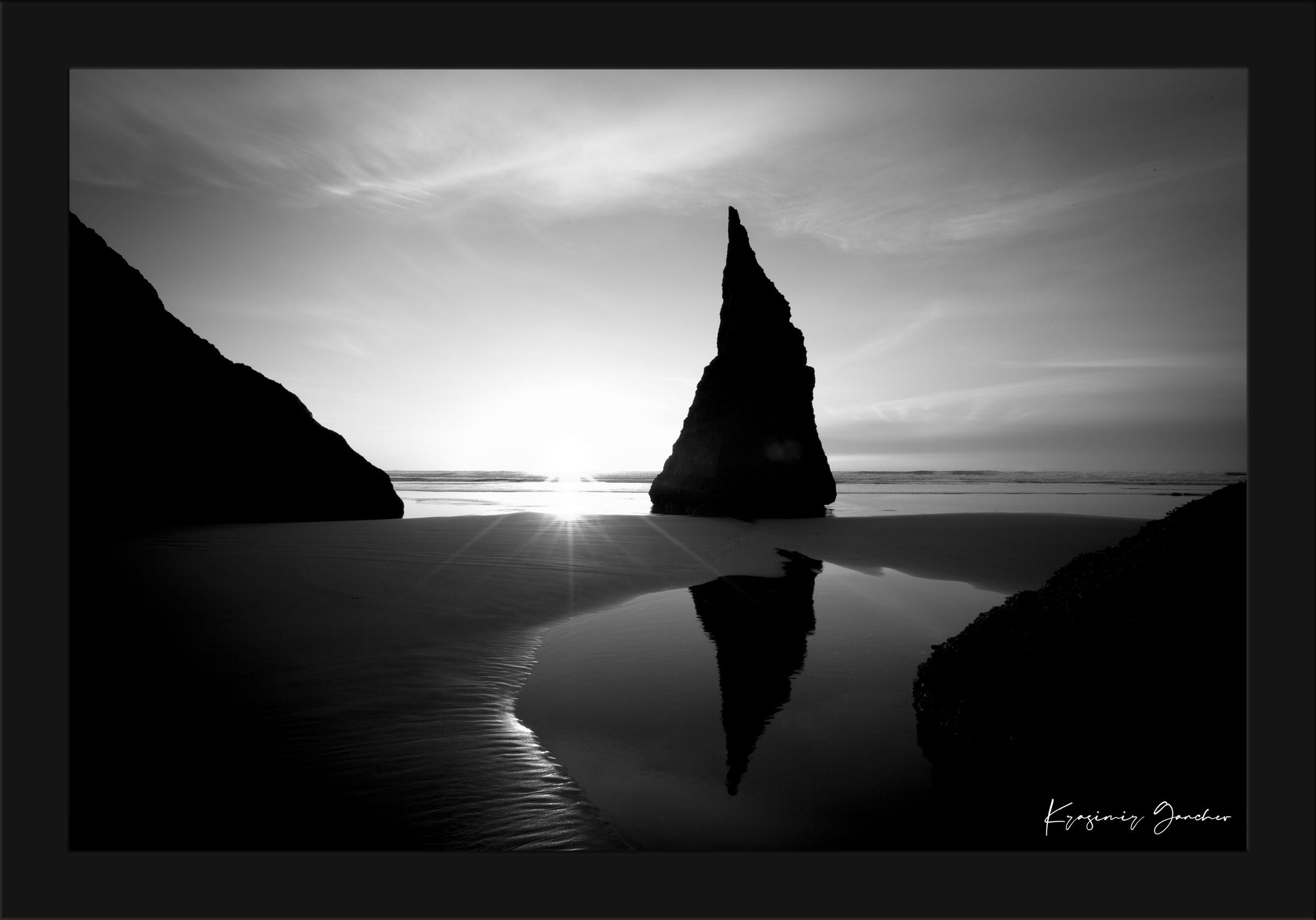 Black and white photograph of the Wizards Hat sea stack at Bandon Beach under hazy sunlight with clouds and ocean reflections. #Finish_Roma Satin Black Frame