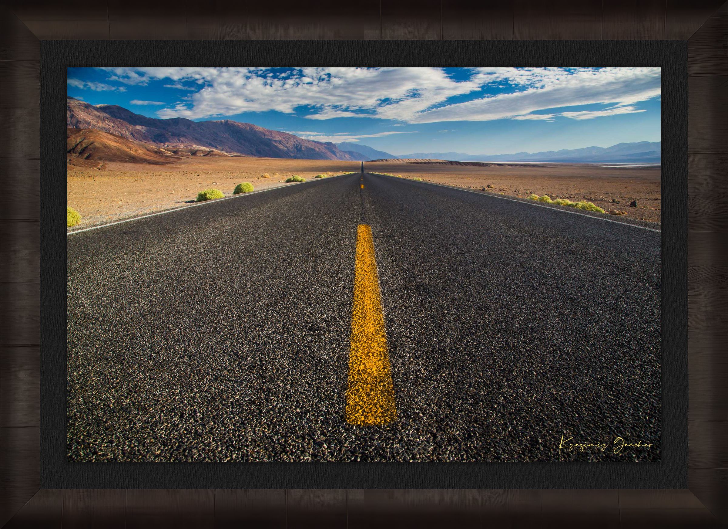 Straight desert road stretching into an open landscape of arid terrain in Death Valley National Park under overcast skies. #Finish_Roma Dark Ash Frame & Dark Liner