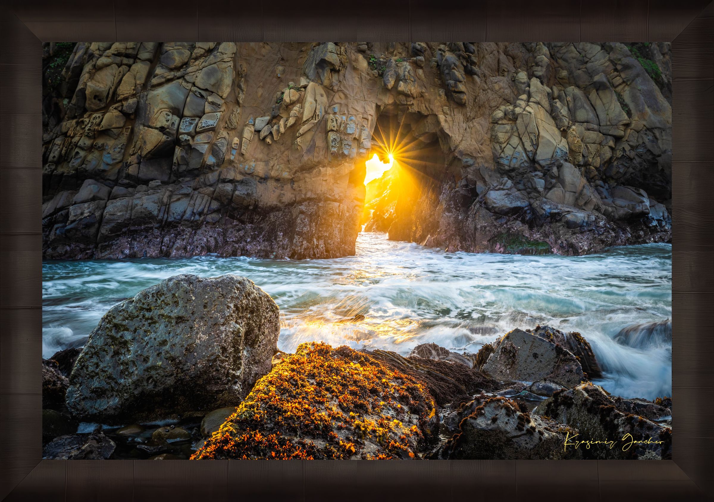 Golden-hour photograph of a coastal arch formed by erosion at Big Sur's rugged shoreline, featuring boulders and open sea. #Finish_Roma Dark Ash Frame