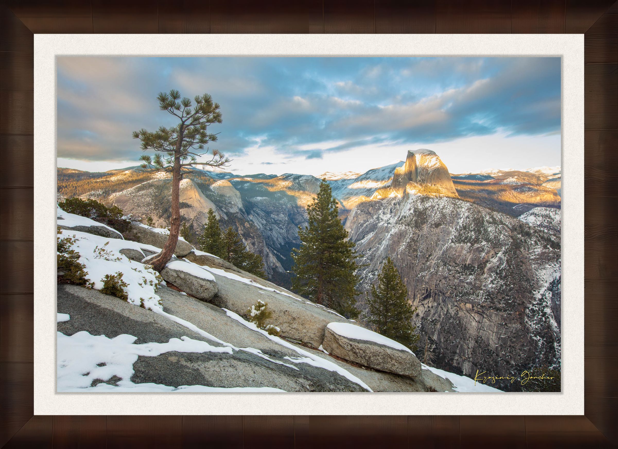 Majestic Half Dome in Yosemite National Park bathed in golden sunset light, covered in snow with wisps of cloud moving across the sky. #Finish_Roma Cigar Leaf Frame & Bright Liner