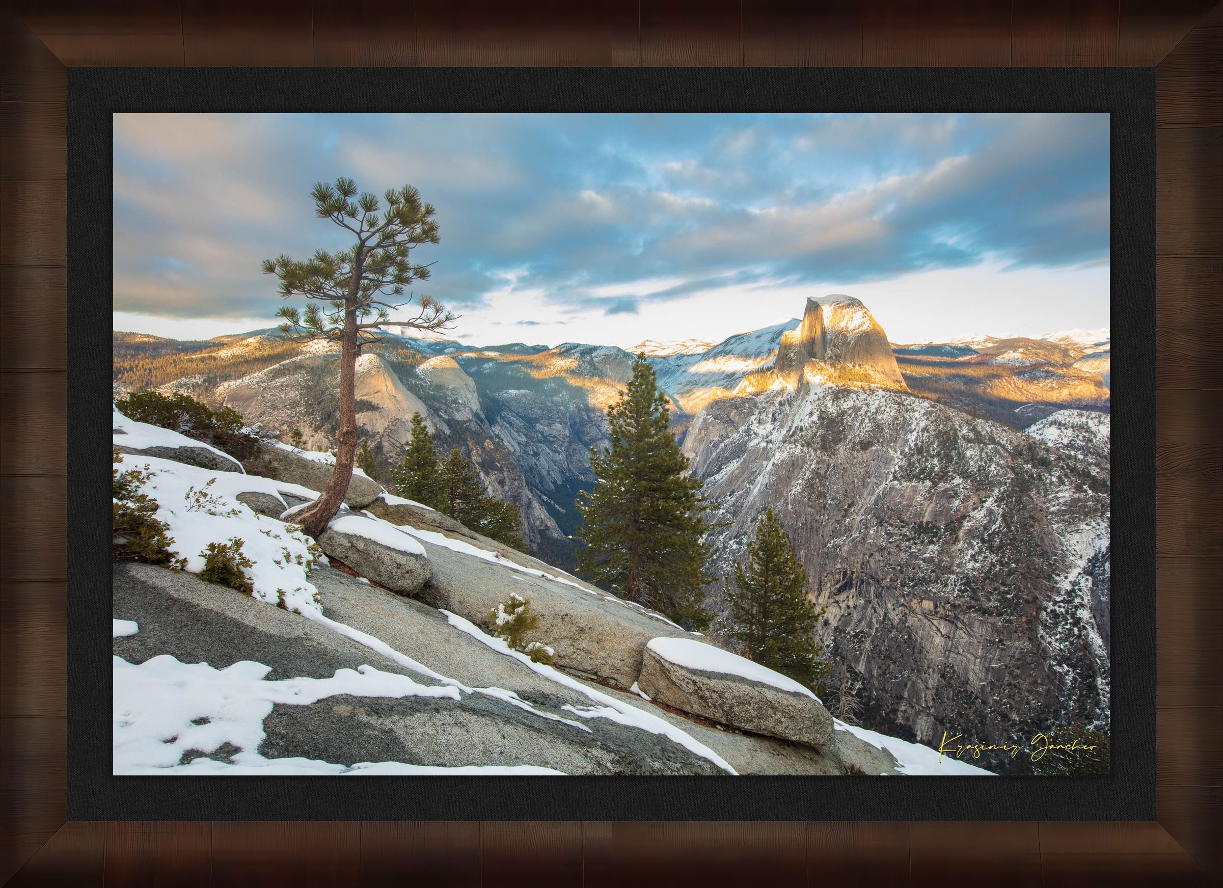 Majestic Half Dome in Yosemite National Park bathed in golden sunset light, covered in snow with wisps of cloud moving across the sky. #Finish_Roma Cigar Leaf Frame & Dark Liner