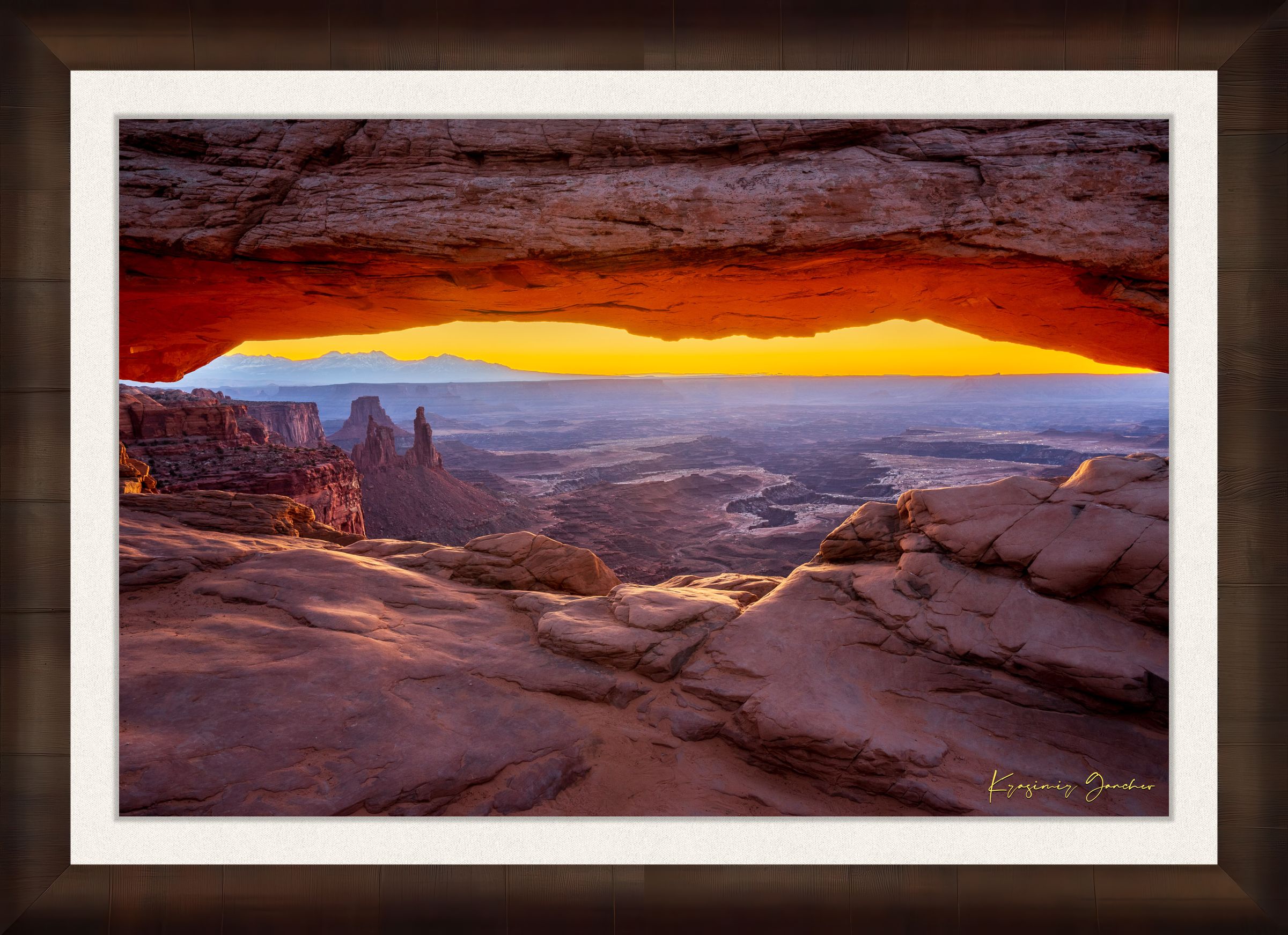 Mesa Arch in Canyonlands National Park framing a sunrise horizon under hazy skies, with golden rays illuminating rock formations. #Finish_Roma Cigar Leaf Frame & Bright Liner