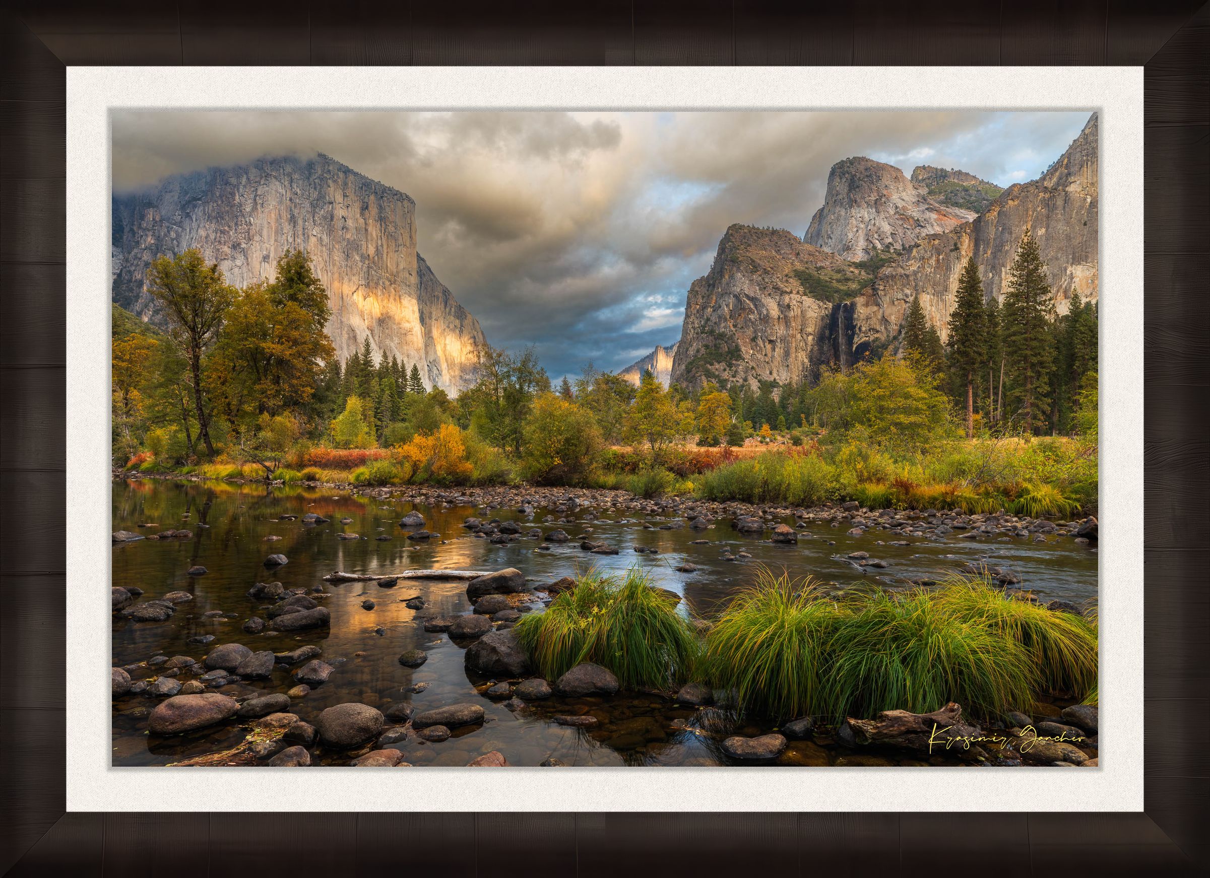 El Capitan at sunset in Yosemite Valley, golden light reflecting off the river amid clouds and seasonal tree colors. #Finish_Roma Dark Ash Frame & Bright Liner