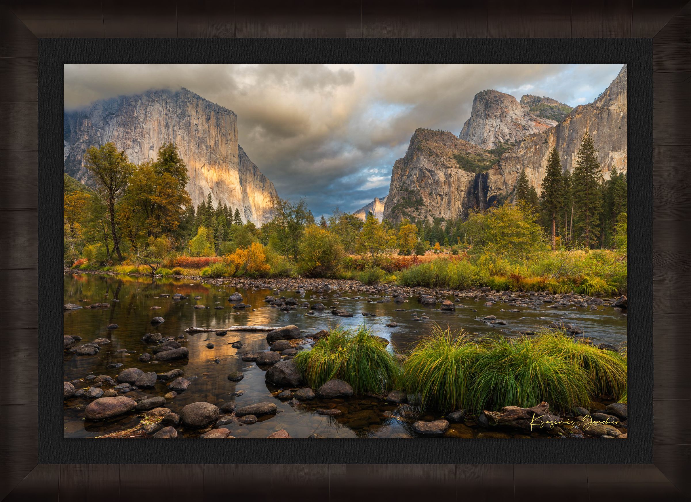 El Capitan at sunset in Yosemite Valley, golden light reflecting off the river amid clouds and seasonal tree colors. #Finish_Roma Dark Ash Frame & Dark Liner