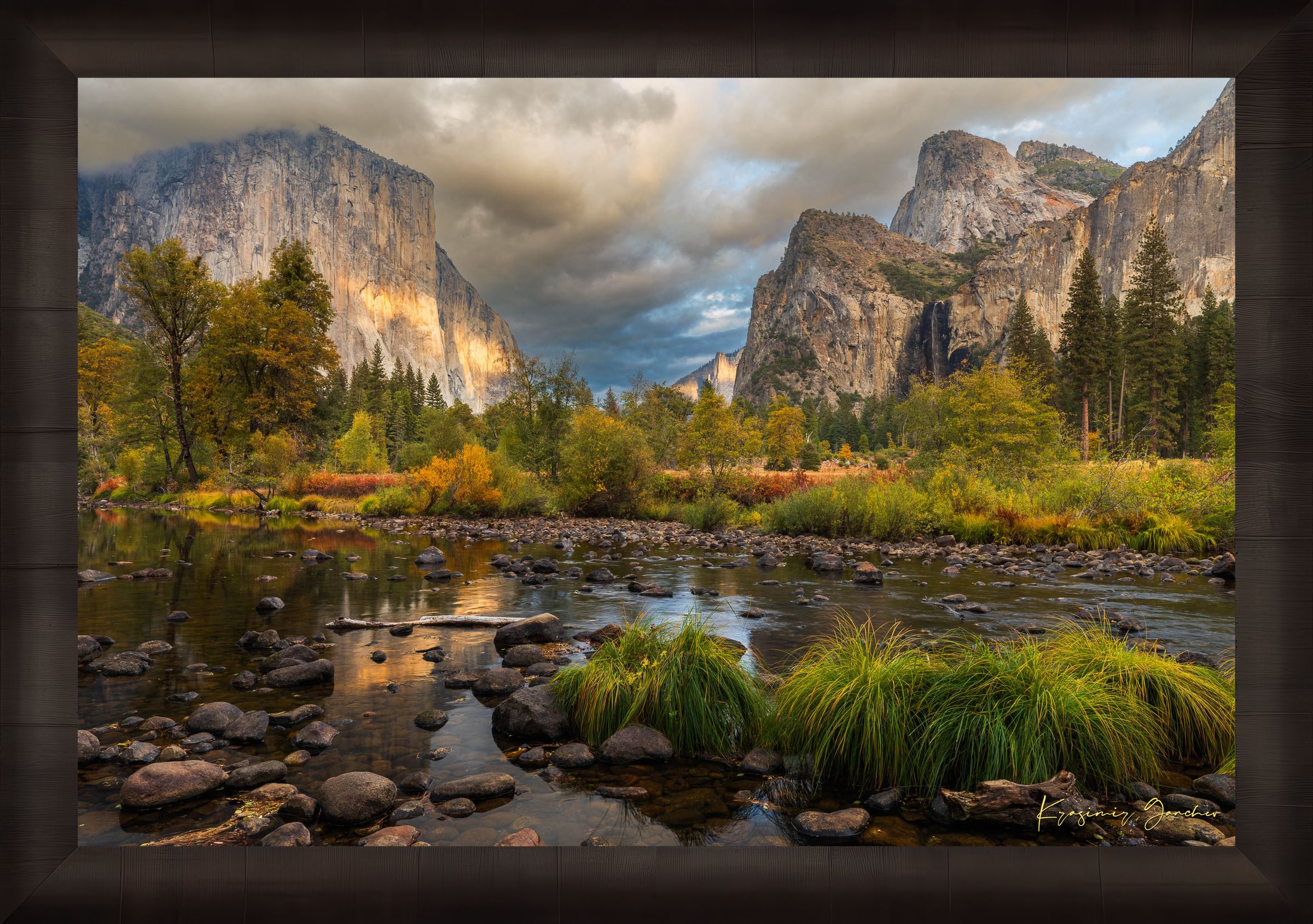 El Capitan at sunset in Yosemite Valley, golden light reflecting off the river amid clouds and seasonal tree colors. #Finish_Roma Dark Ash Frame
