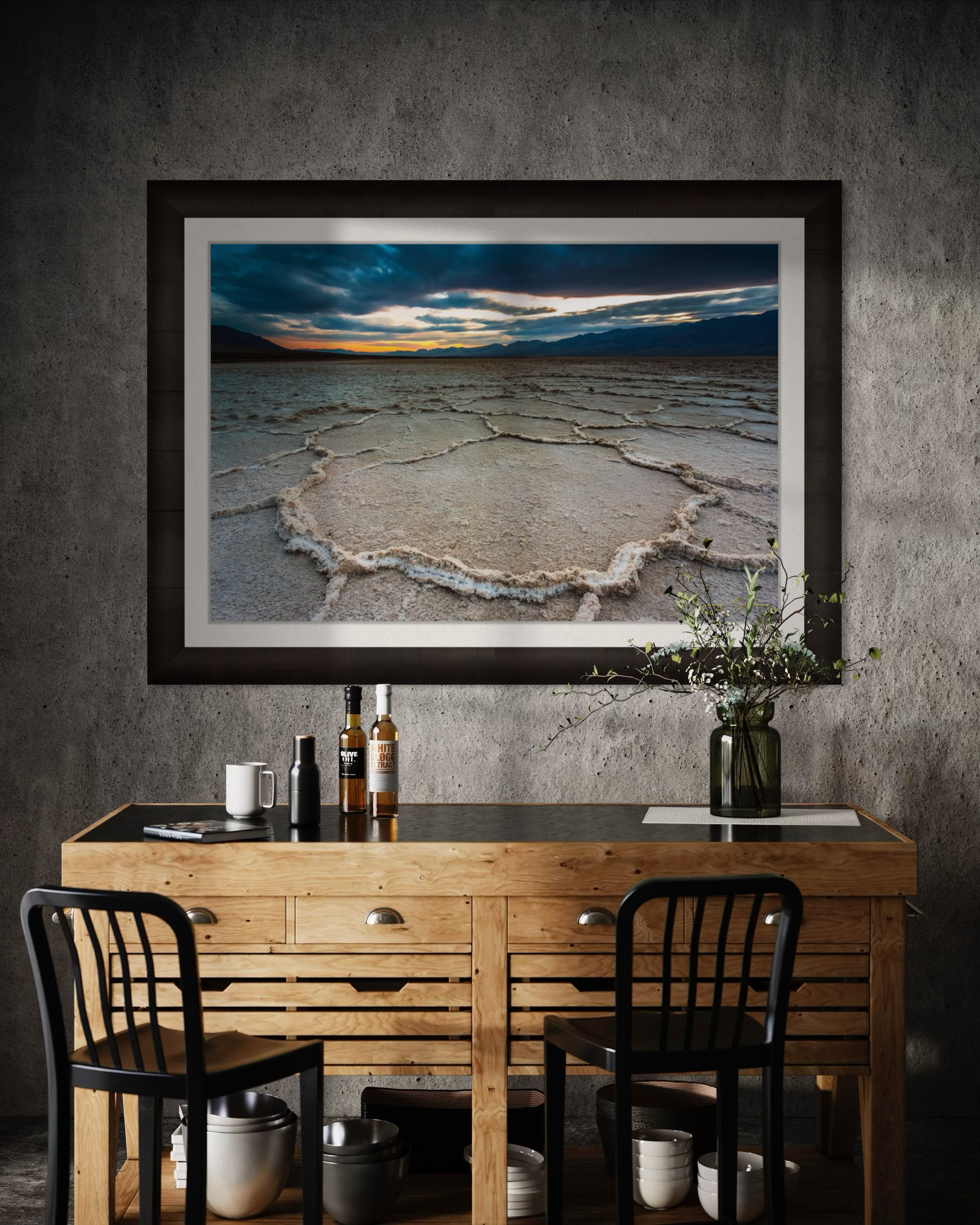 Expansive desert salt flat of Badwater Basin beneath a sky filled with storm clouds and setting sun in Death Valley. #Finish_Roma Dark Ash Frame & Bright Liner