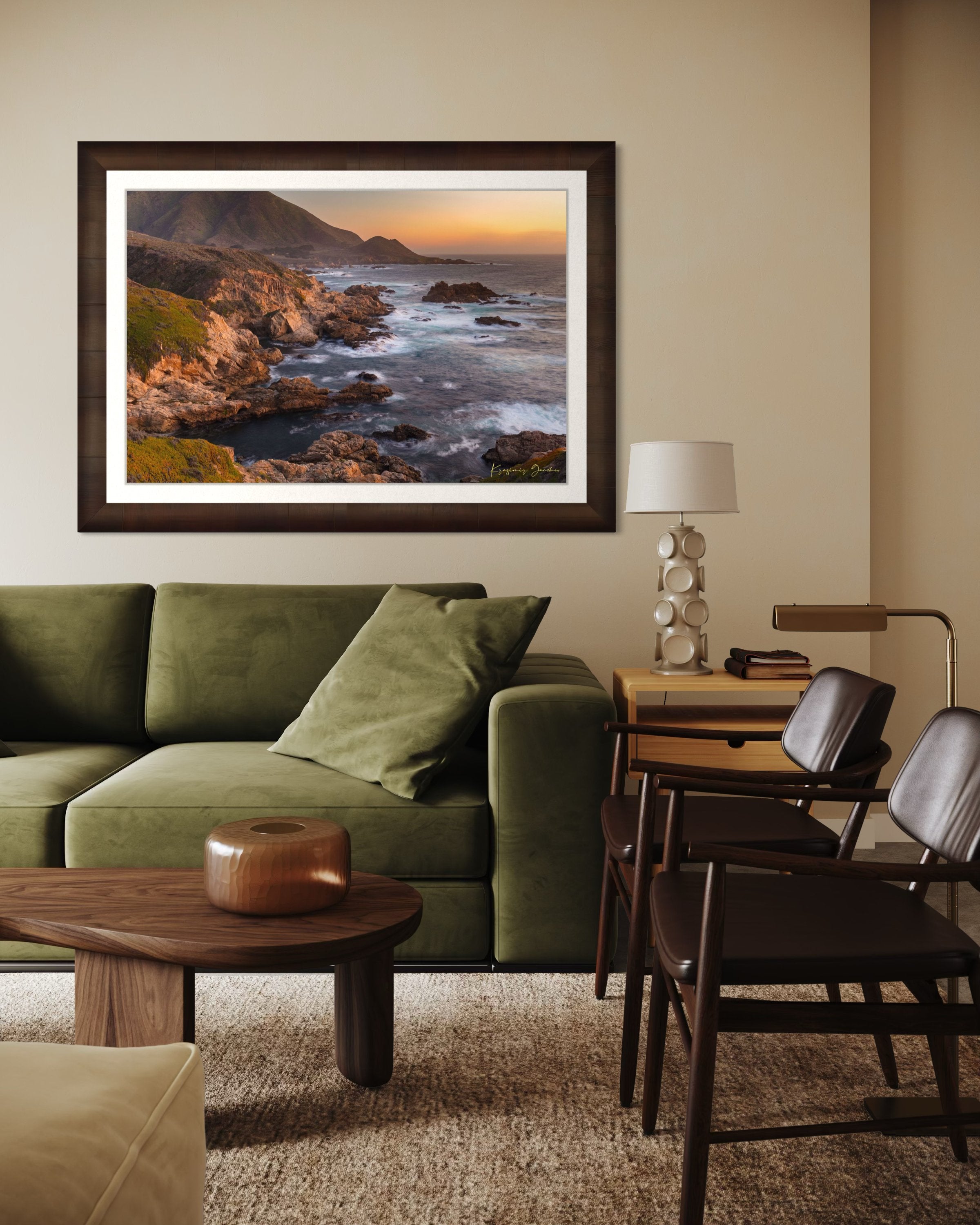 Rugged coastline of Big Sur featuring dark boulder formations, green slopes, ocean waves, and soft sunset glow across land and sea. #Finish_Roma Cigar Leaf Frame & Bright Liner
