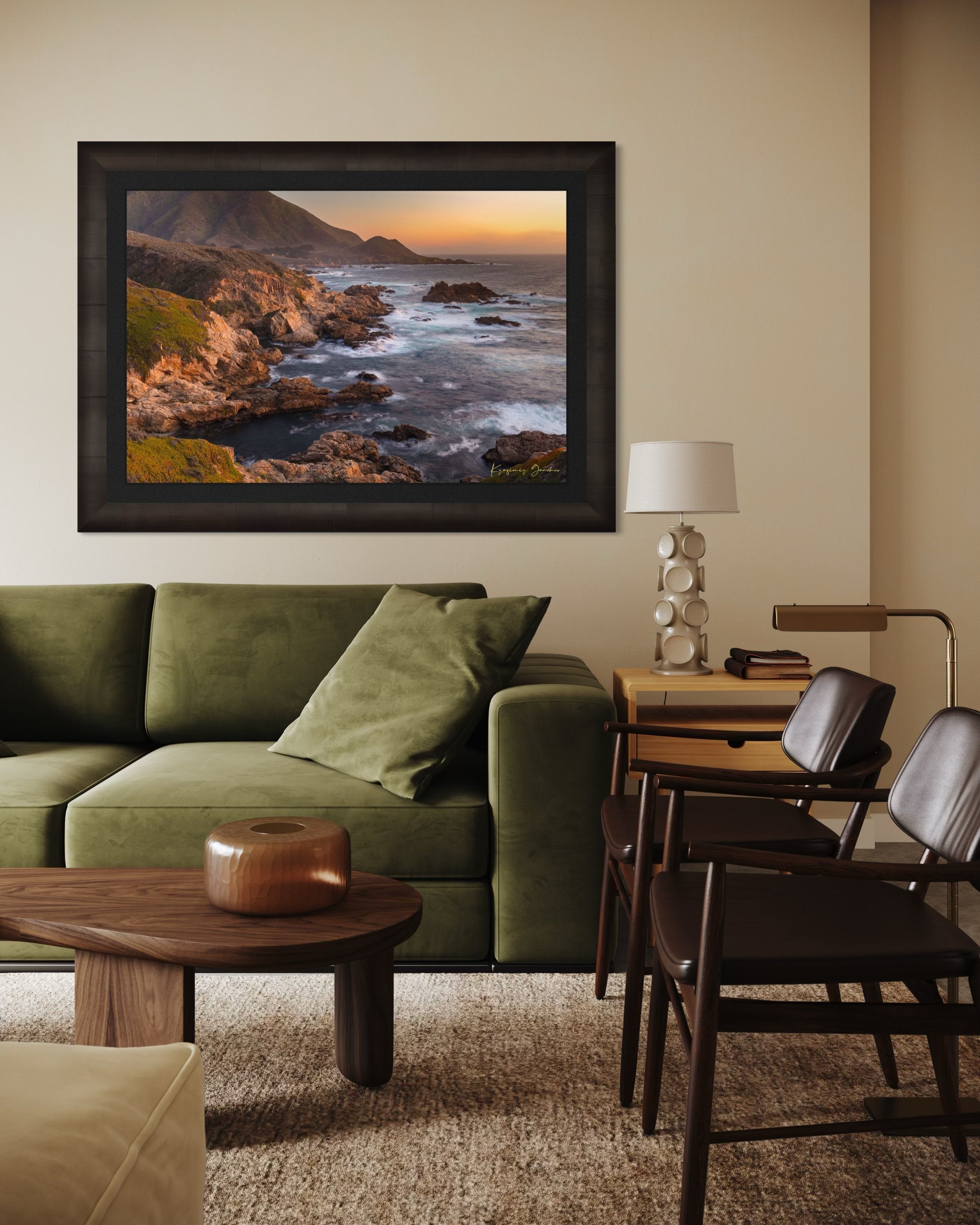 Rugged coastline of Big Sur featuring dark boulder formations, green slopes, ocean waves, and soft sunset glow across land and sea. #Finish_Roma Dark Ash Frame & Dark Liner