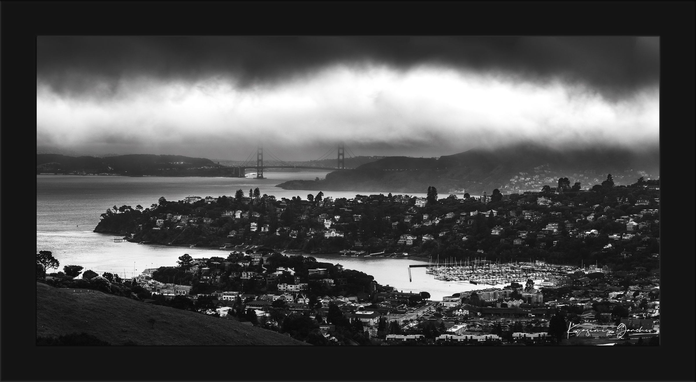 Golden Gate Bridge visible through fog at dusk above the San Francisco Bay with Tiburon cityscape in foreground. #Finish_Roma Satin Black Frame