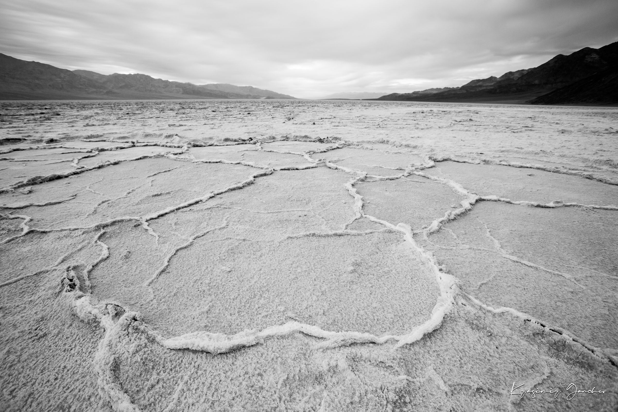 Cracked salt flat landscape in Death Valley National Park during sunset, showing textured surface under clear skies. #Finish_Acrylic Recess