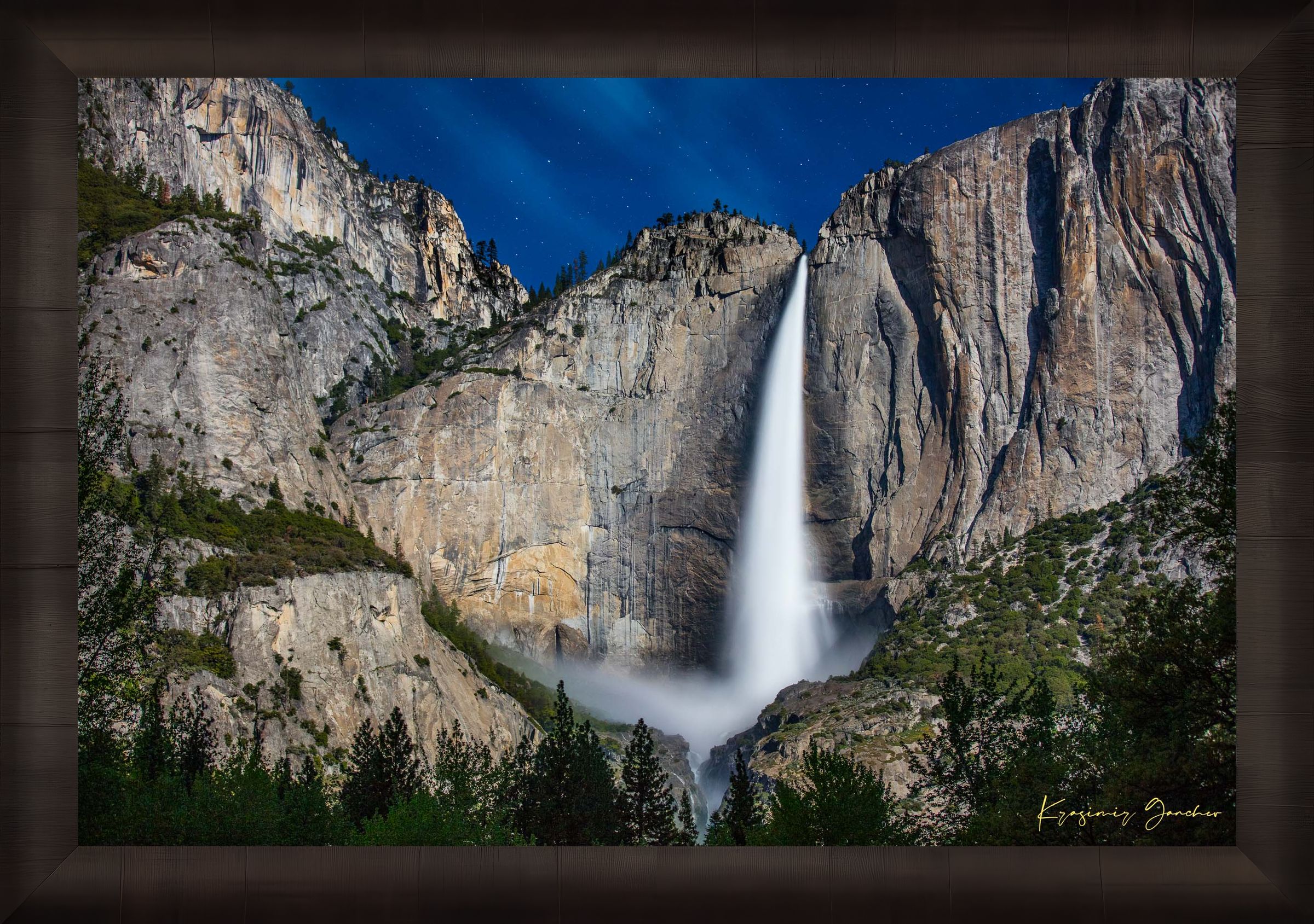 Upper Yosemite Falls illuminated by moonlight against a dark mountainous backdrop at night with cloud cover. #Finish_Roma Dark Ash Frame