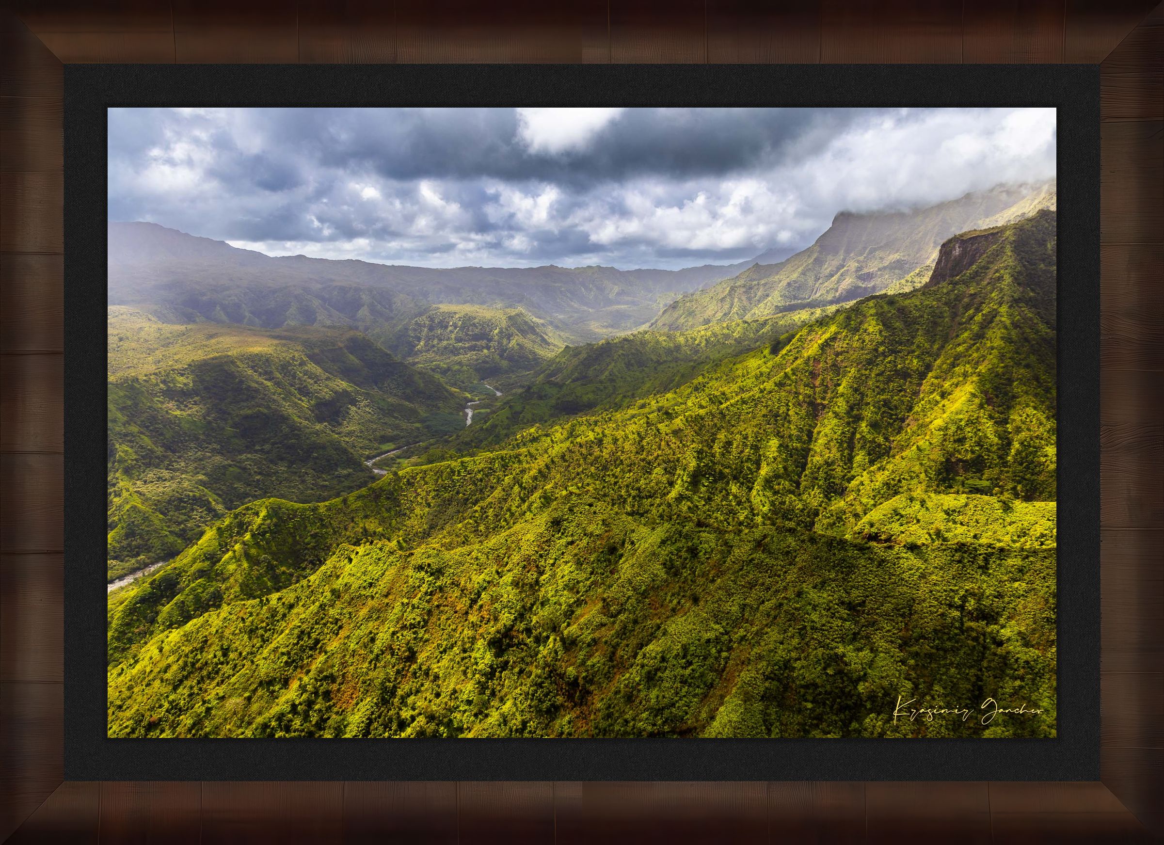Expansive aerial view of a mountainous valley in Kauai illuminated by daylight, covered in low-lying cloud. #Finish_Roma Cigar Leaf Frame & Dark Liner