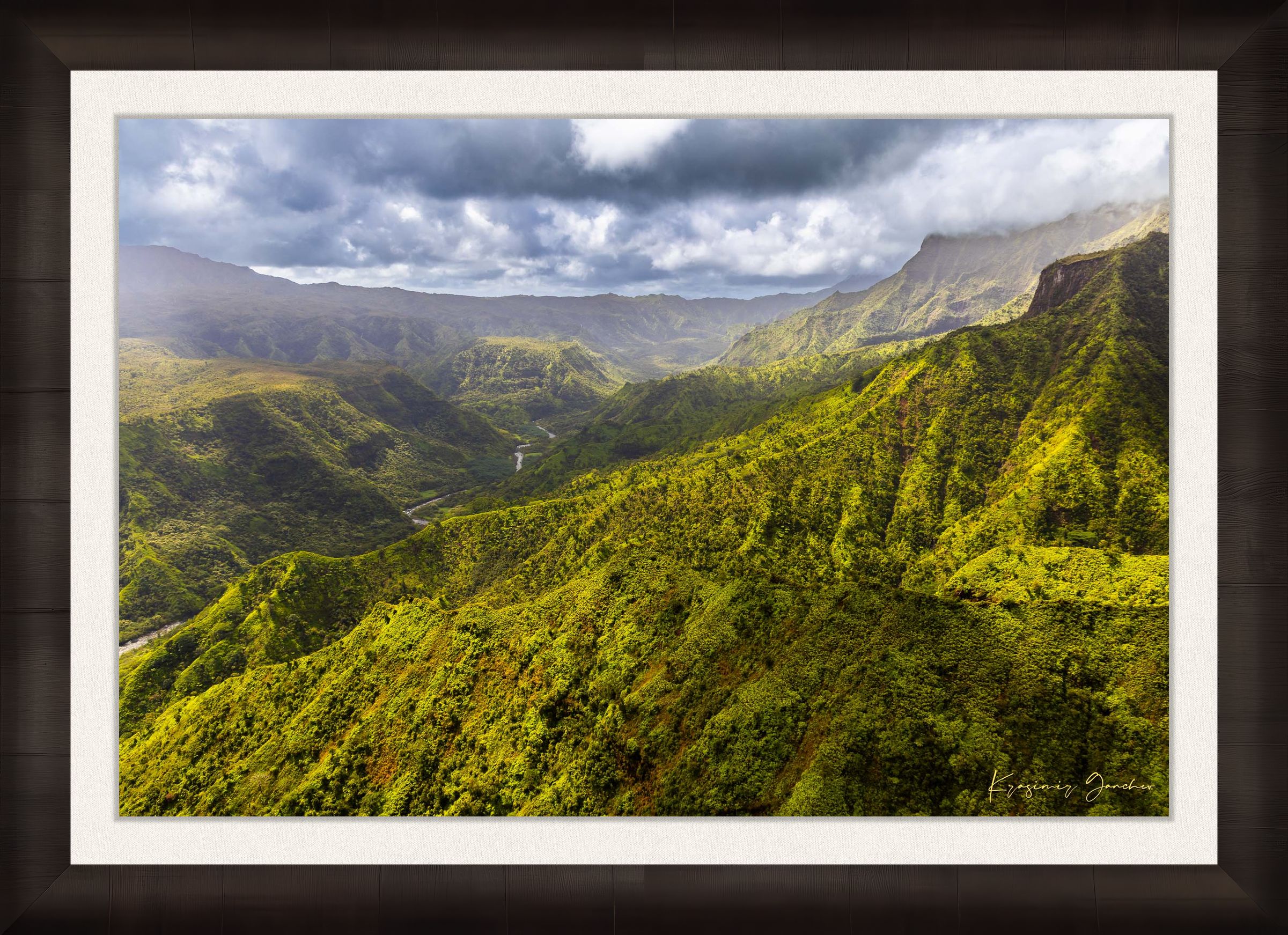 Expansive aerial view of a mountainous valley in Kauai illuminated by daylight, covered in low-lying cloud. #Finish_Roma Dark Ash Frame & Bright Liner