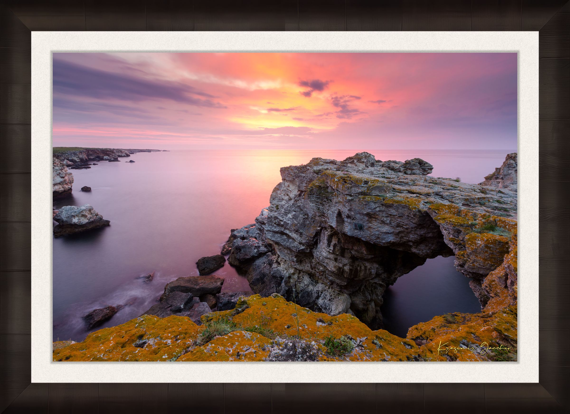 The natural arch formation of the Tyulenovo Arch at dawn in Tyulenovo, Bulgaria, lit by sunrise and surrounded by vegetation. #Finish_Roma Dark Ash Frame & Bright Liner