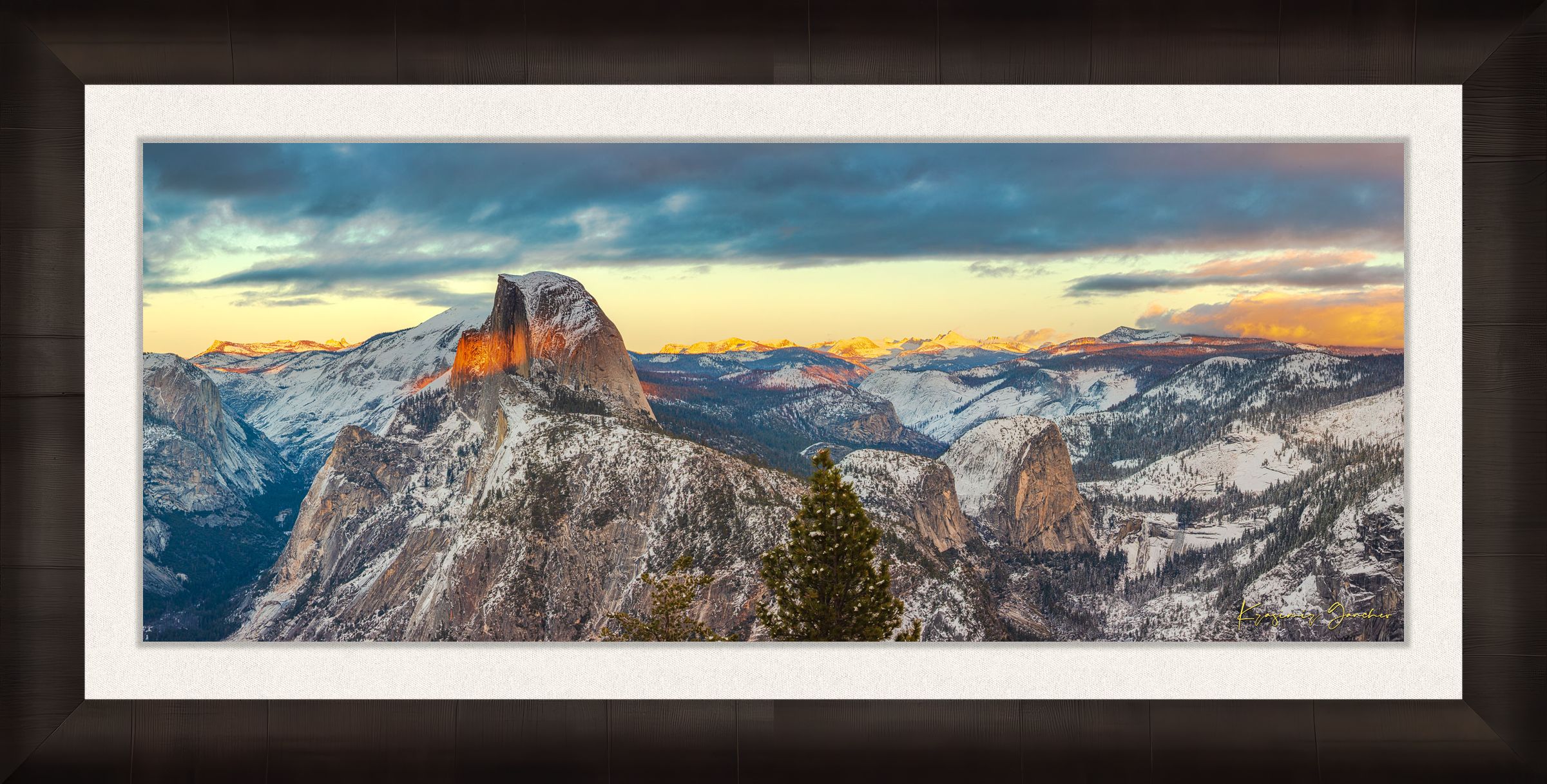 Sunset view of Half Dome monolith with dynamic shadows and sunlight over snow-dusted peaks and clouds in Yosemite National Park. #Finish_Roma Dark Ash Frame & Bright Liner