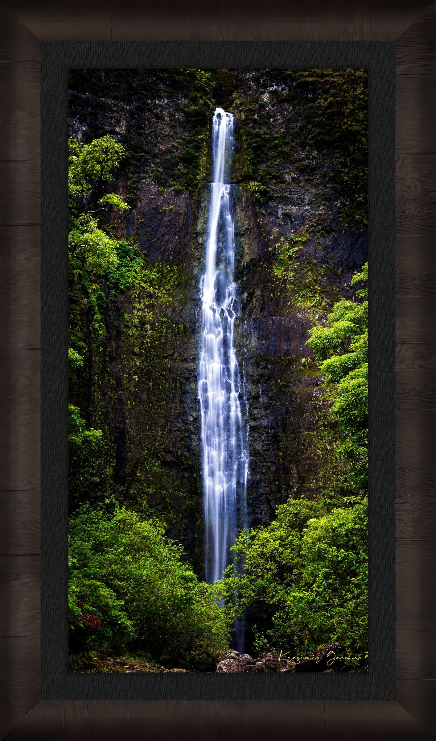 Waterfall cascading down cliff face within Na Pali Coast region of Kauai under daylight conditions. #Finish_Roma Dark Ash Frame & Dark Liner