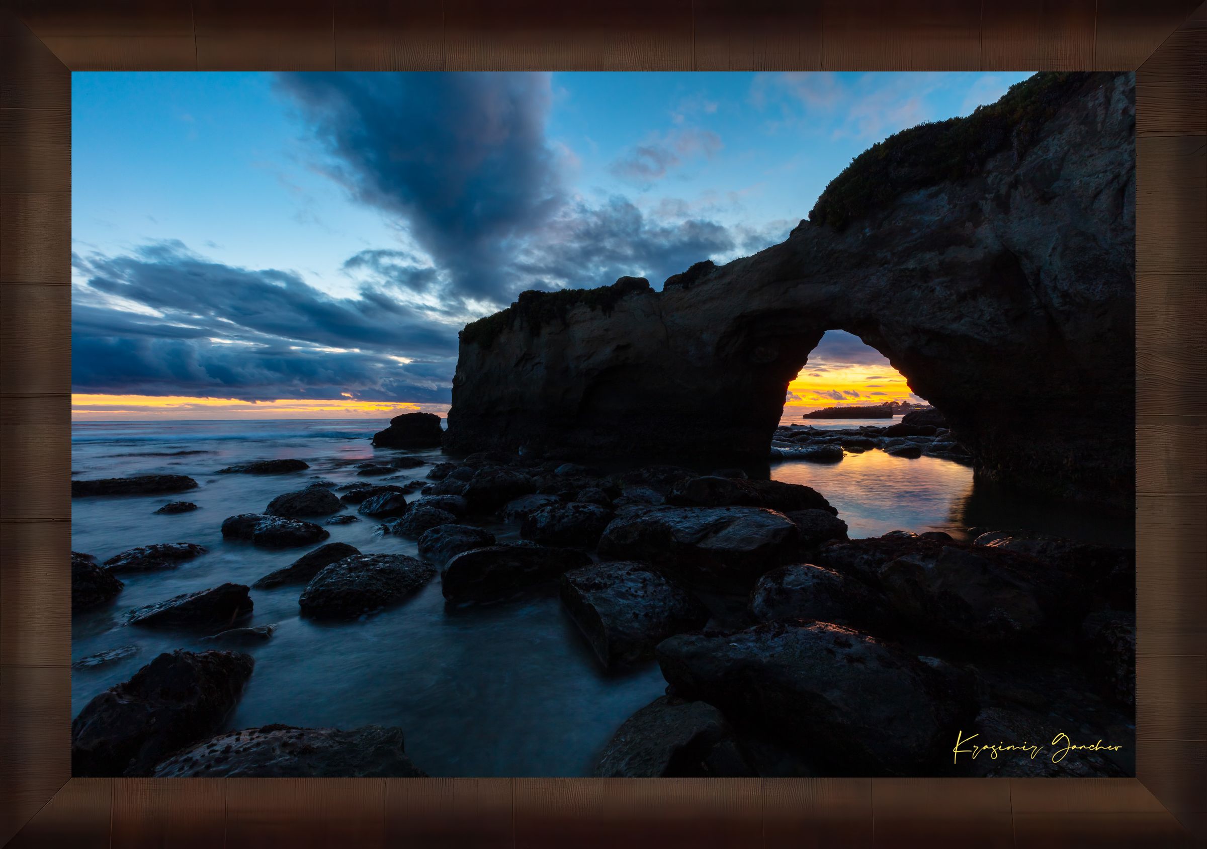 Natural rock arch framing sunset over the Pacific Ocean with waves moving around boulders at Santa Cruz coastline. #Finish_Roma Cigar Leaf Frame