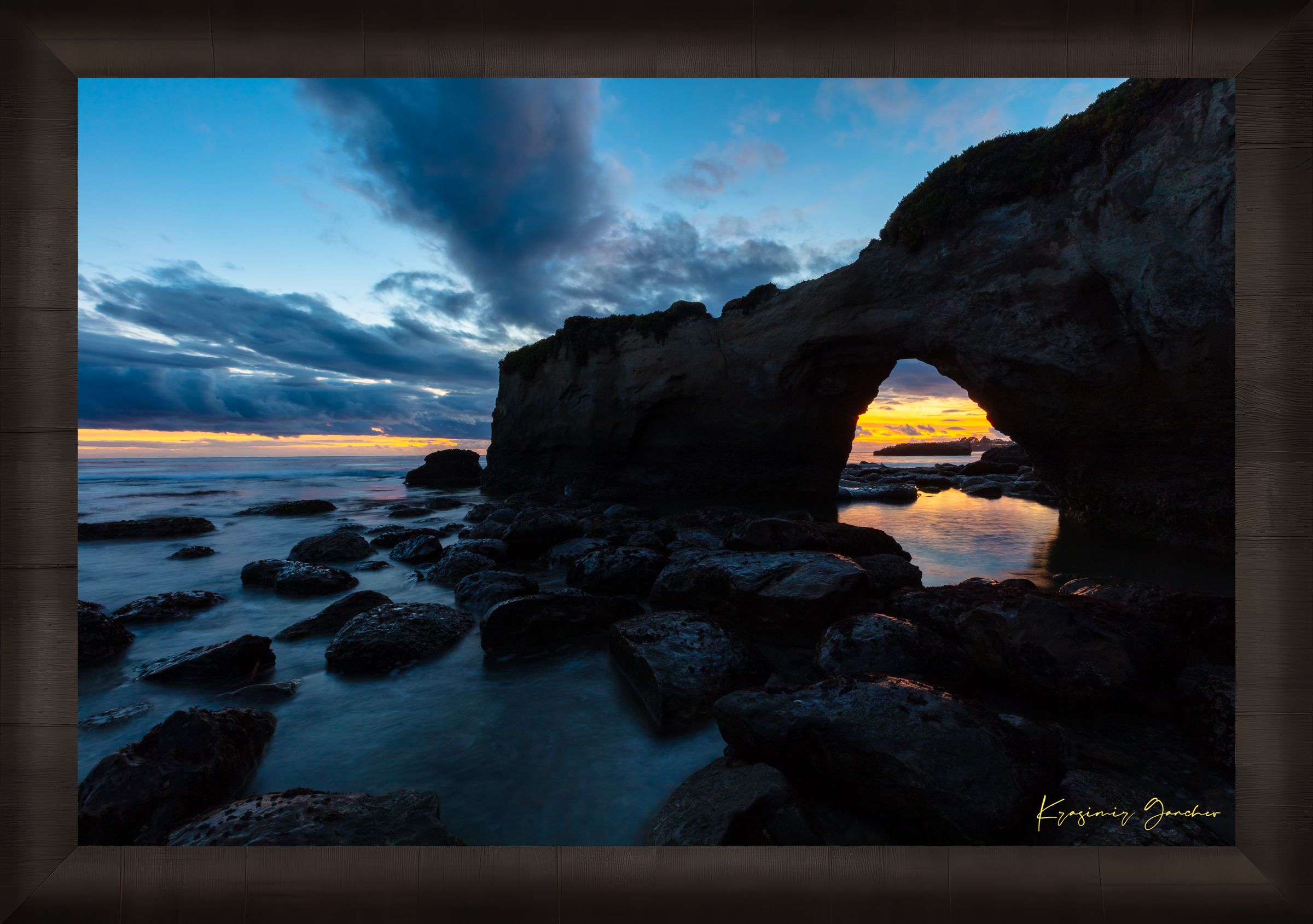 Natural rock arch framing sunset over the Pacific Ocean with waves moving around boulders at Santa Cruz coastline. #Finish_Roma Dark Ash Frame