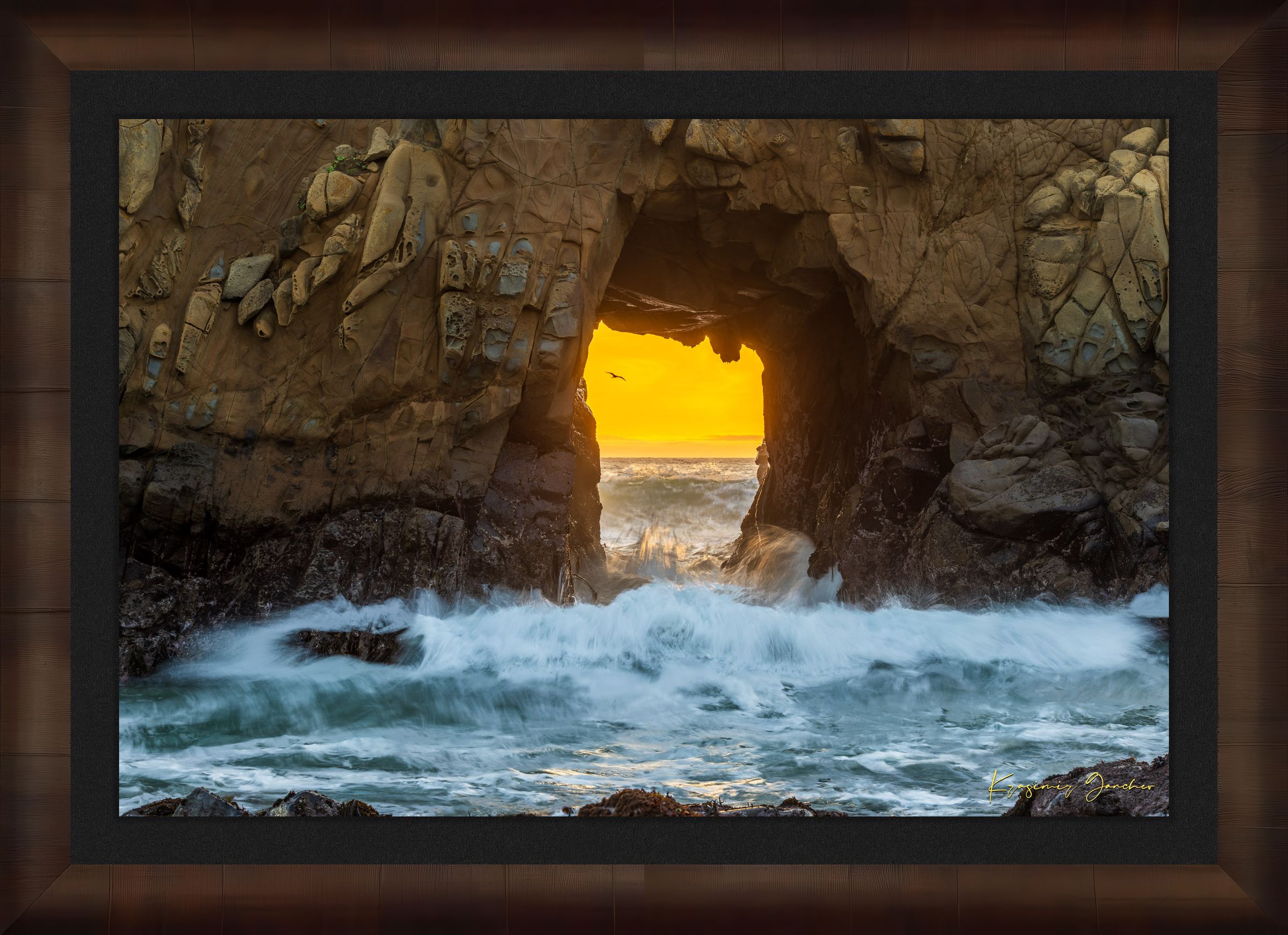 Natural rock arch on the Pacific coast of Big Sur framed by a vivid sunset, wave motion softened by long exposure. #Finish_Roma Cigar Leaf Frame & Dark Liner