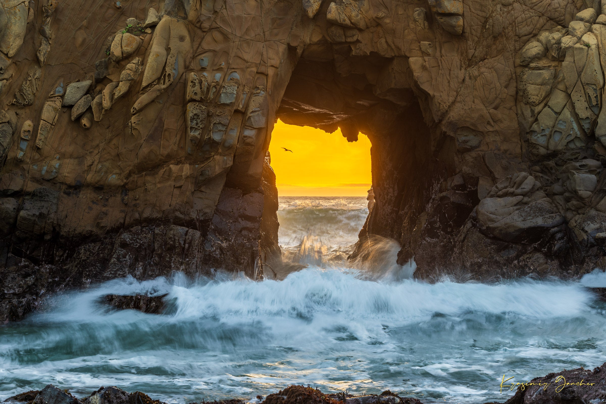 Natural rock arch on the Pacific coast of Big Sur framed by a vivid sunset, wave motion softened by long exposure. #Finish_Acrylic Recess