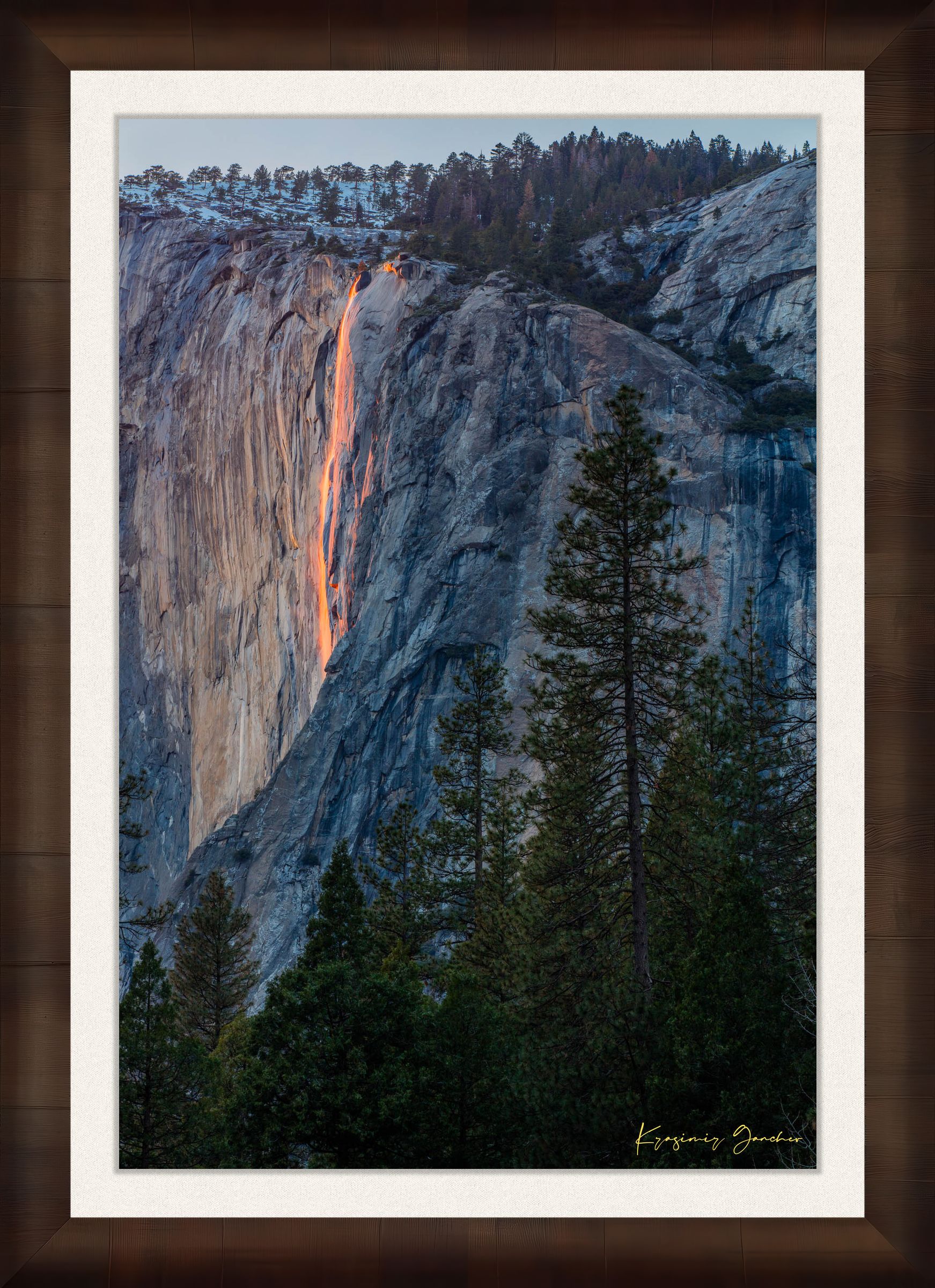 Firefall illuminated waterfall cascading on El Capitan monolith with foreground trees framing the scene during a cloudy sunset in Yosemite. #Finish_Roma Cigar Leaf Frame & Bright Liner