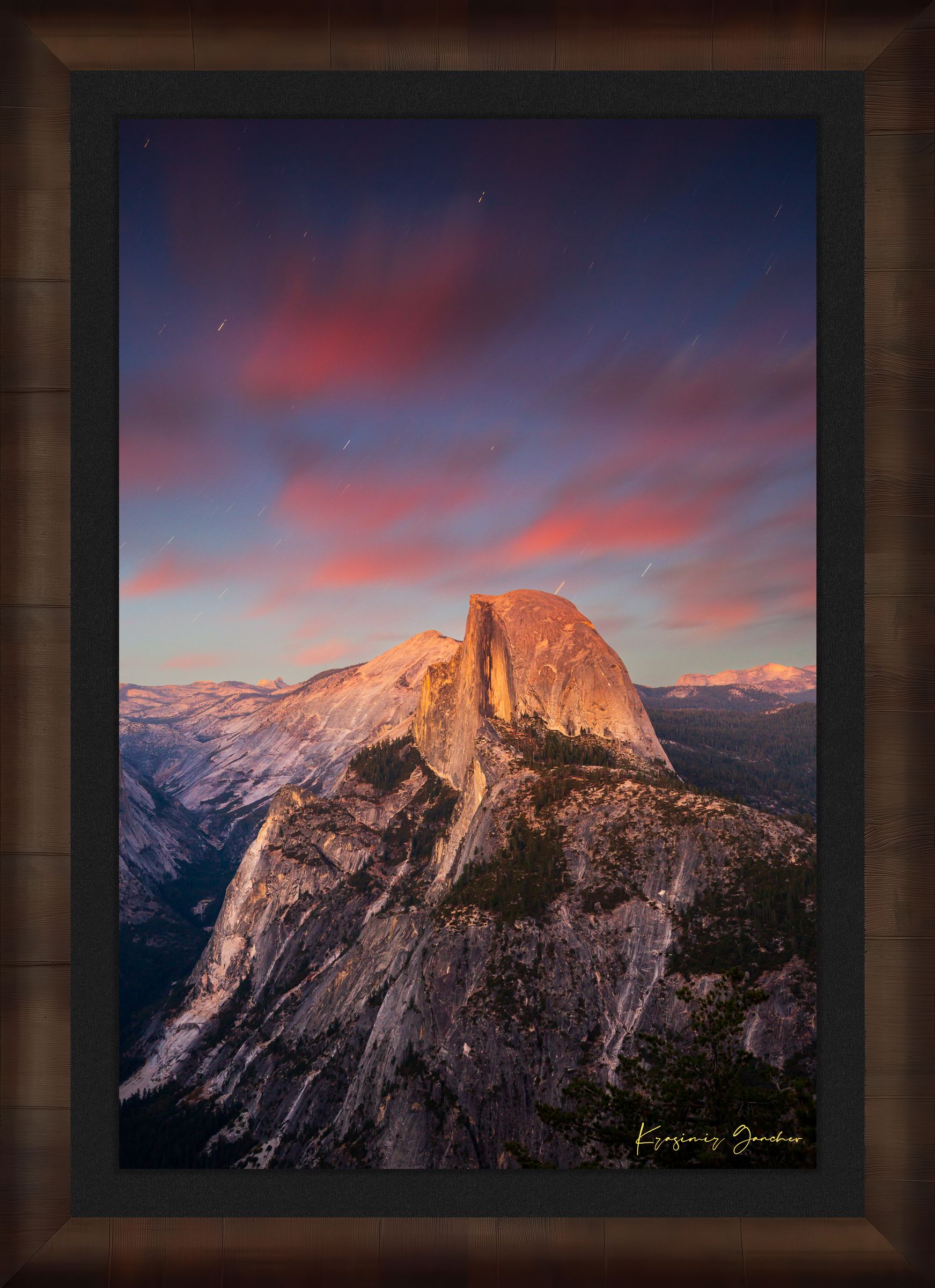 Granite monolith of Half Dome illuminated by dusk and stars, set against a sky filled with star trails above Yosemite National Park. #Finish_Roma Cigar Leaf Frame & Dark Liner